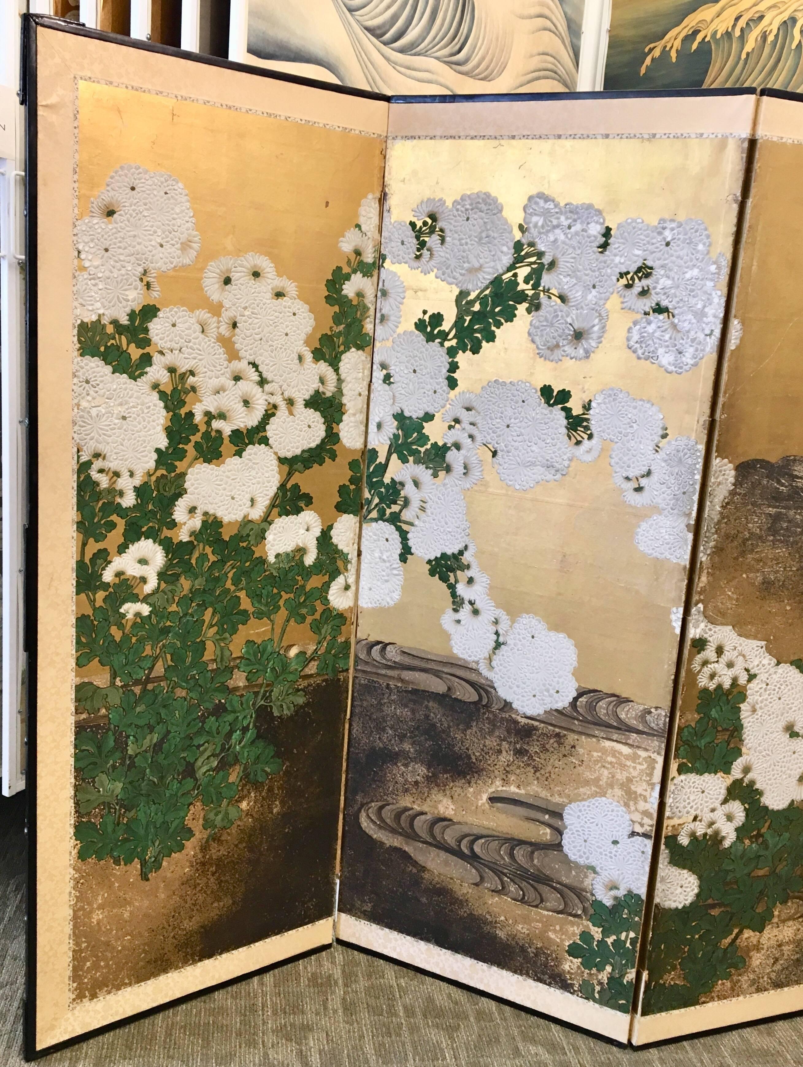 A beautiful six-panel early 19th century Japanese screen with raised gesso flowers and stylized stream, hand-painted on gold leaf.