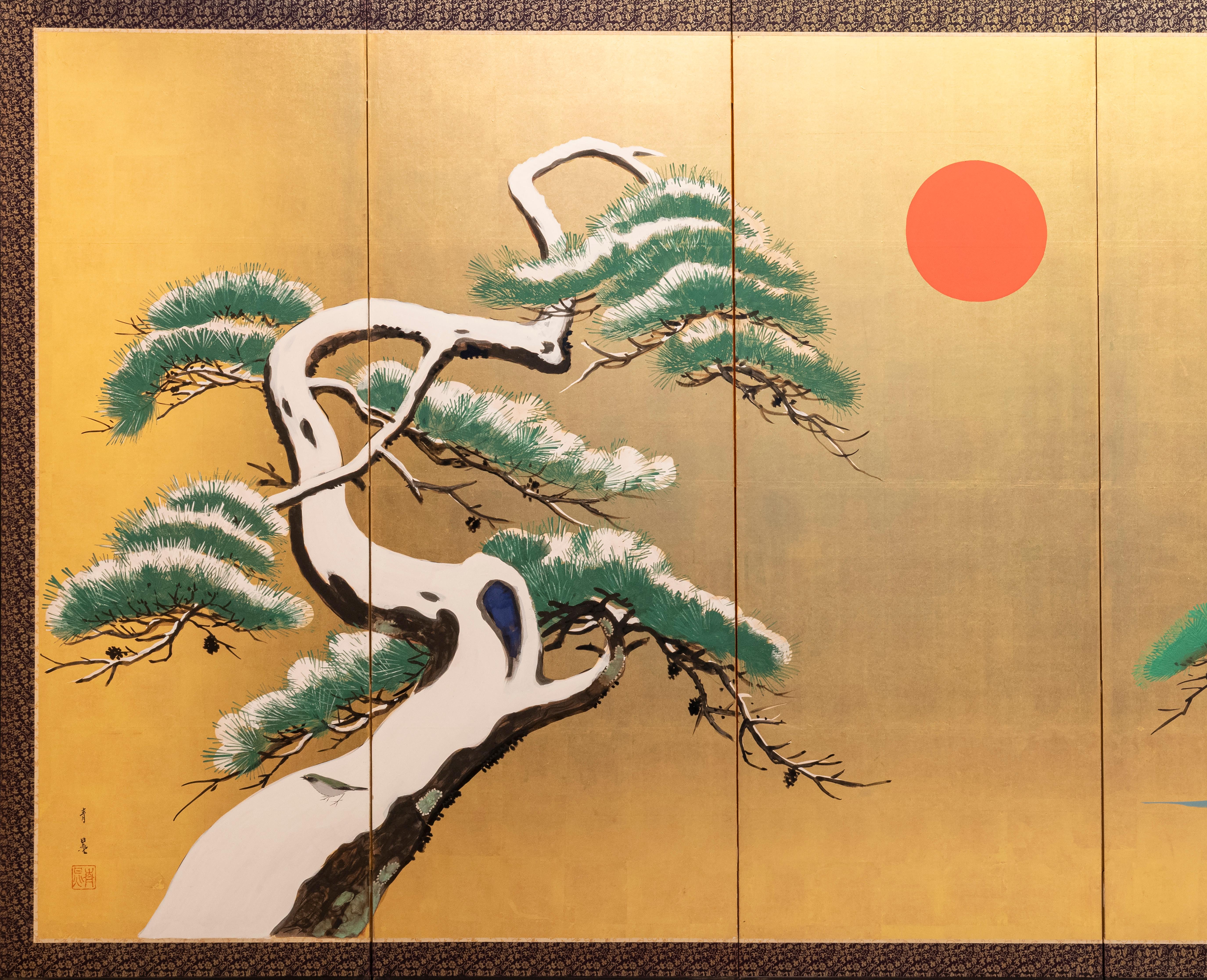 A six-panel folding screen with a gold-leaf ground, depicting two pine trees with a red sun at the center.
On the left, a snow-covered pine is shown with a sinuous, knotted trunk and branches bending under the weight of the white snow, which stands