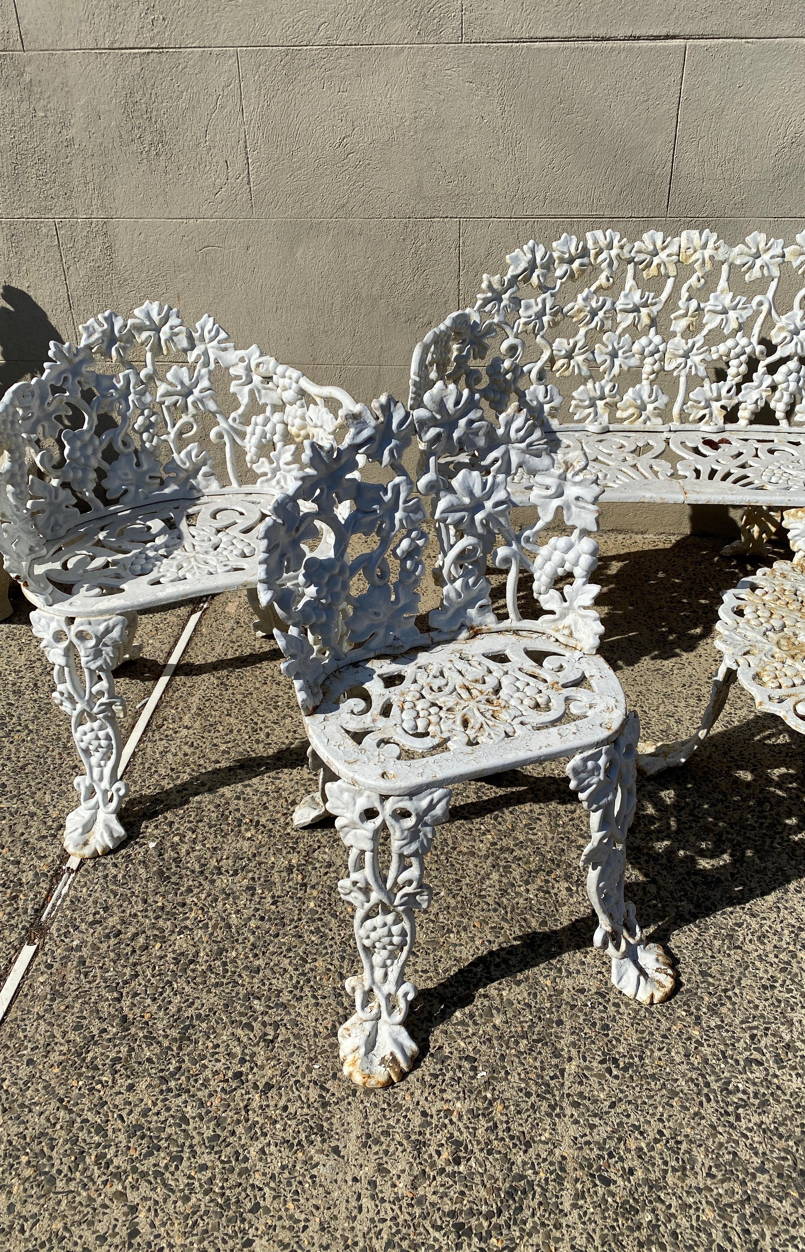 A hard to find six piece cast iron outdoor garden furniture set made by the Atlanta Stove Works The set includes a double settee, 2 larger barrel back chairs, 2 smaller side chairs and a round cocktail table. The original matching set with grape and