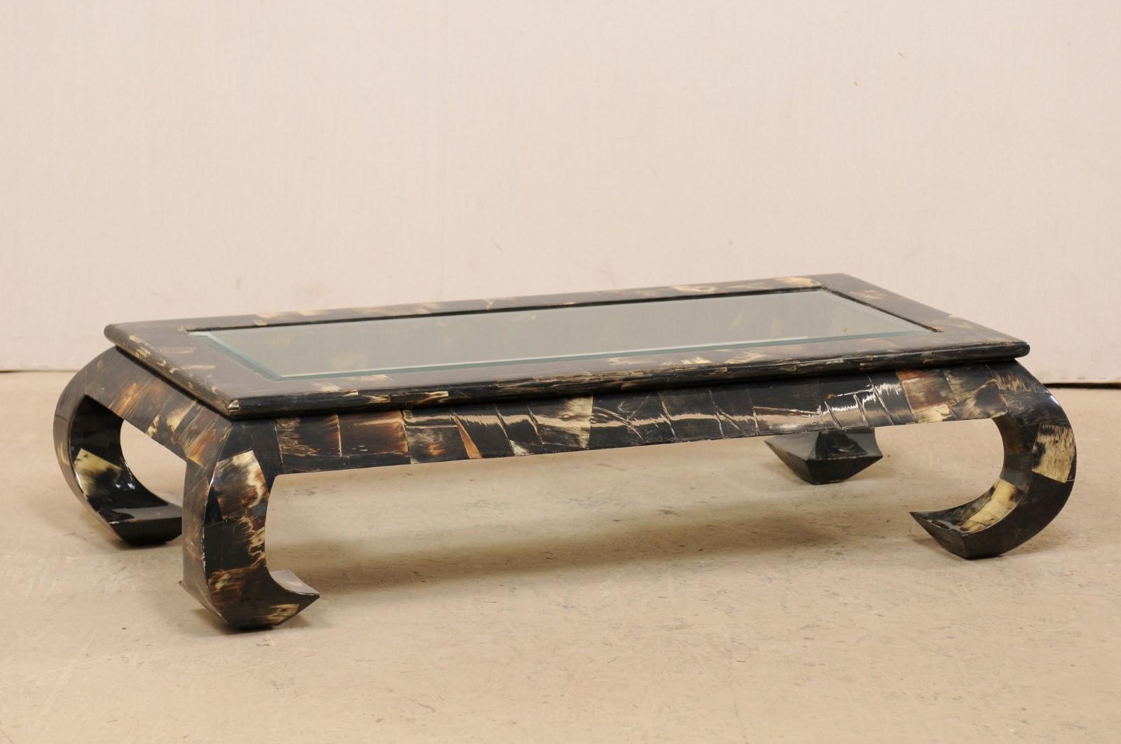 A vintage coffee table with water buffalo veneer and mirrored top. This rectangular-shaped coffee table, created in modern, sleek design lines, features a frame of water buffalo Horn veneer, creating much visual interest to this piece. While the top