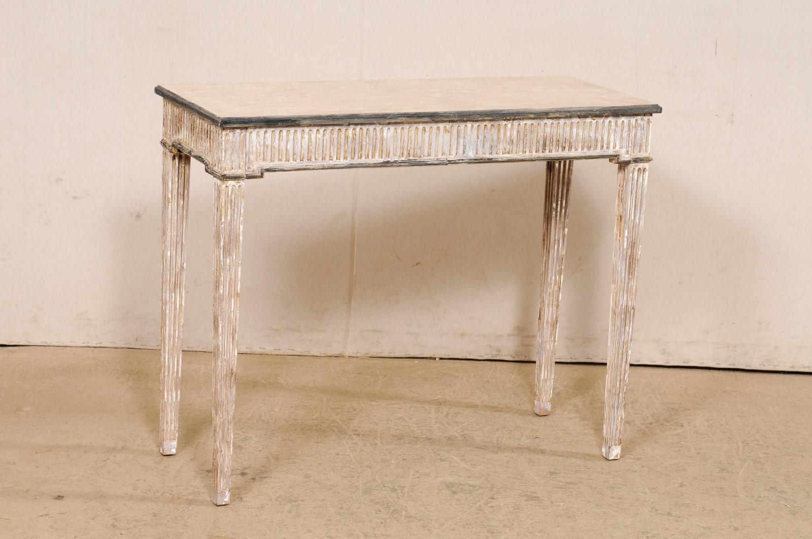 An Italian flute-carved and painted wood console table from the mid 20th century. This vintage table from Italy has a slightly overhanging rectangular-shaped top, resting upon an apron which houses two half-sized drawers that are hidden along the