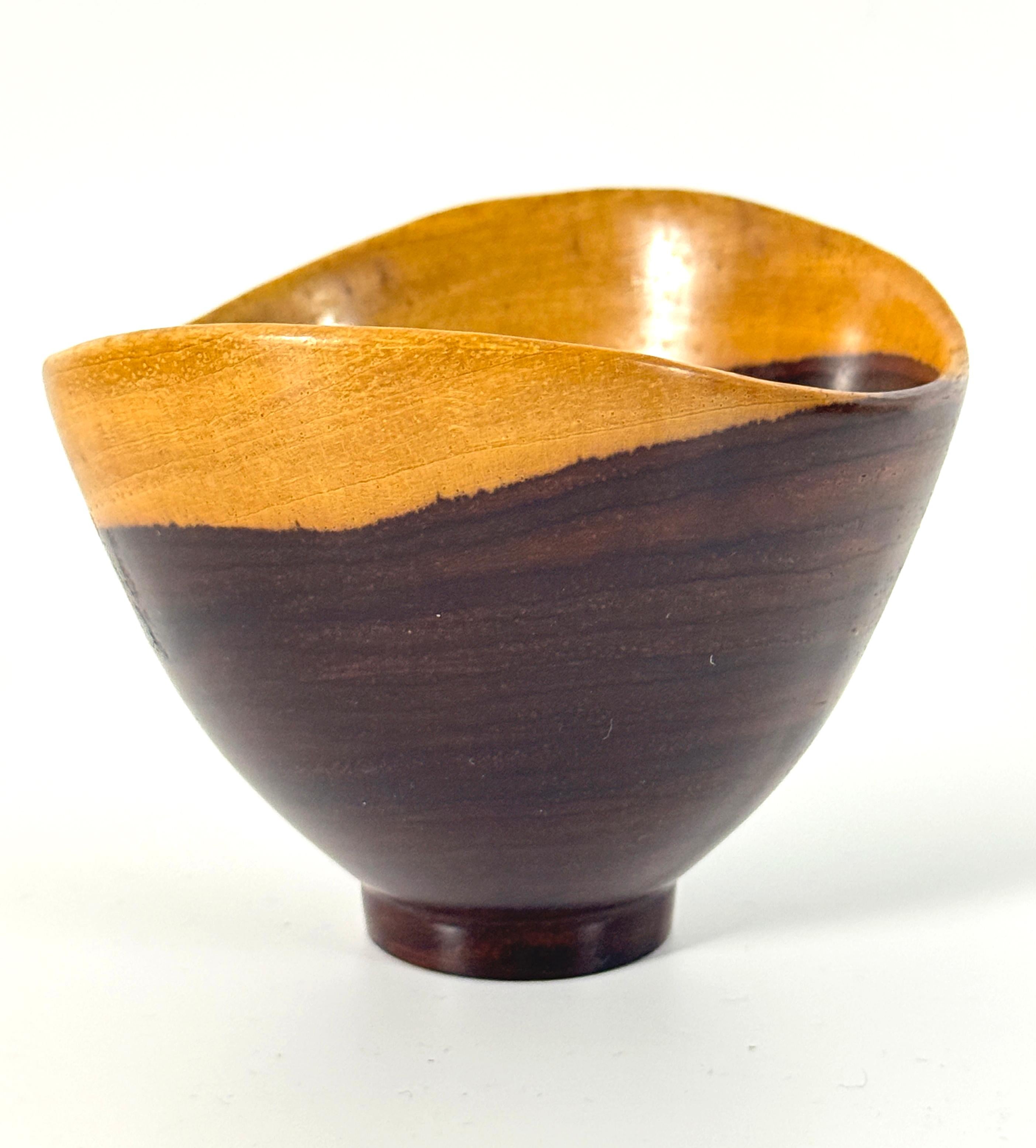 Una ciotola di Studio A, splendidamente realizzata da un unico pezzo di legno duro, con un elegante bordo biondo affusolato e sollevata su un piede corto. Questa ciotola è di piccole dimensioni e sarebbe un bel pezzo d'accento insieme ad altre