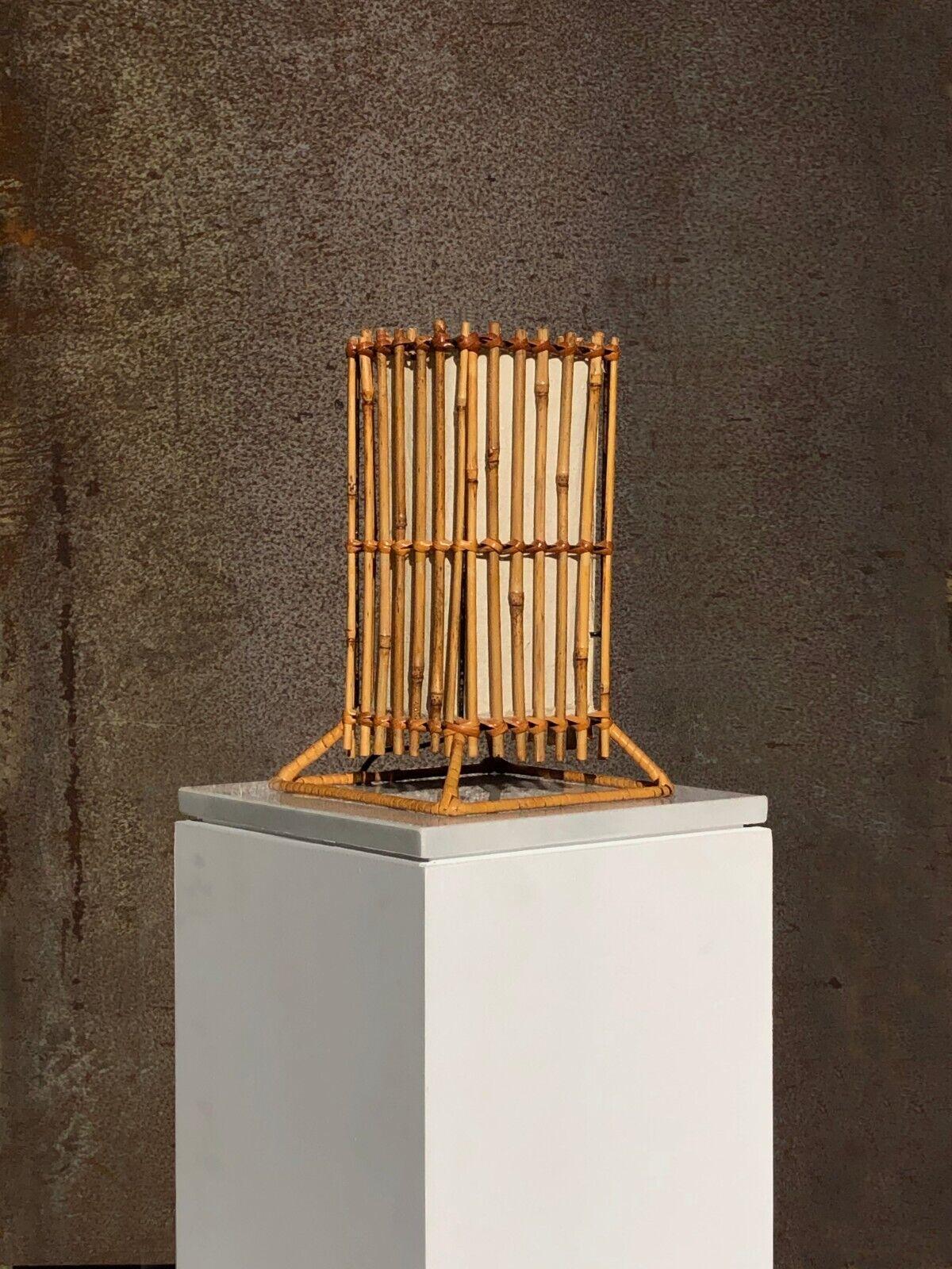 A small Architectural, Modernist, Rustic Modern, Brutalist, Fifties table lamp or night light, square base with a pyramidal structure, topped by a cubic lampshade made of vertical bamboo rods woven on a square structure, itself around a very fine