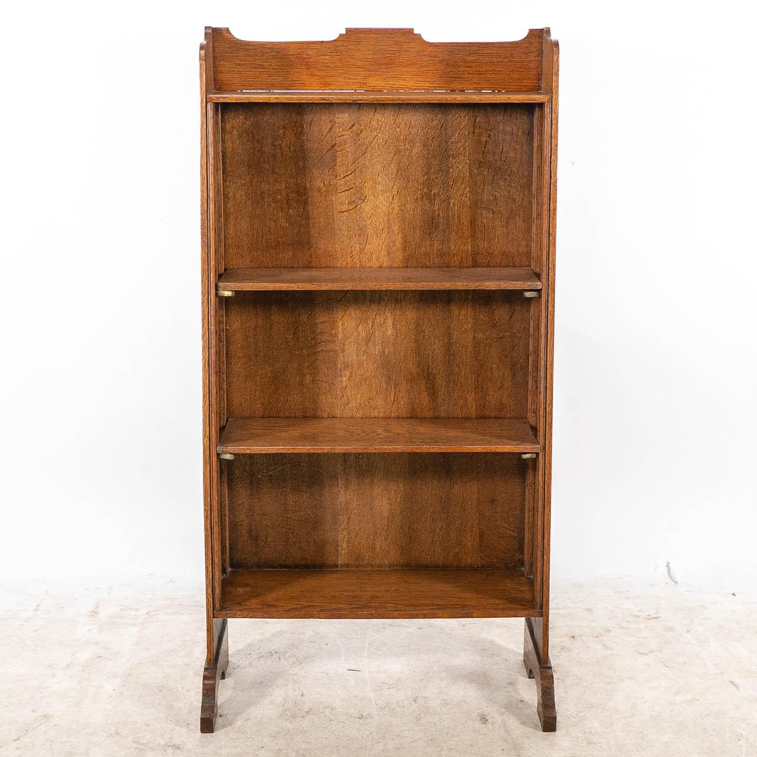 Ein kleines Bücherregal im Arts-and-Crafts-Stil mit einfachem, geformtem Oberteil, das zum Boden hin allmählich tiefer wird, mit verstellbaren Einlegeböden und verlängerten Füßen, die dem Regal einen festen Stand verleihen und es vor dem Umfallen