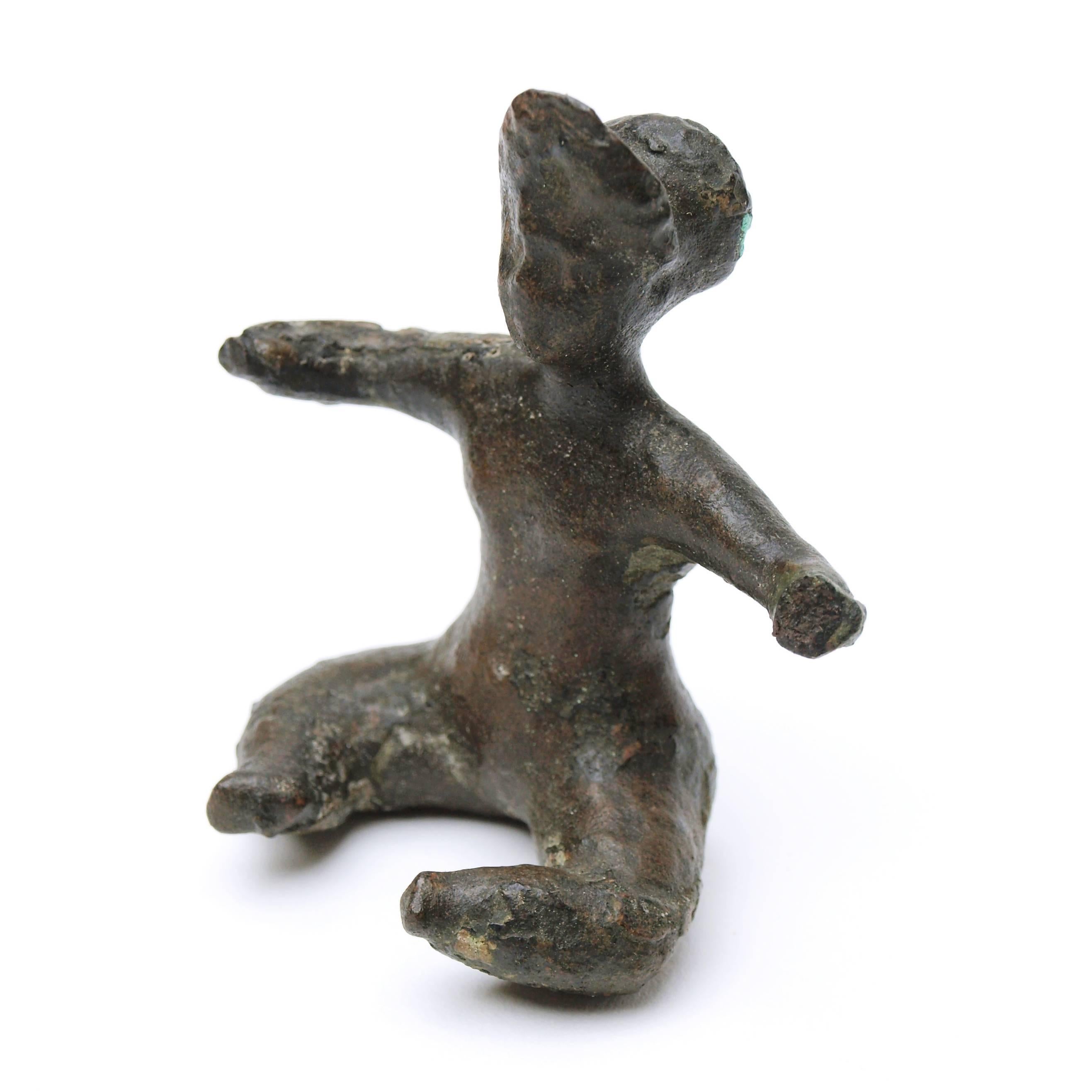 A small bronze Baubo figurine from Roman Egypt. Baubo is a Greek goddess associated with sexual liberation and healing and has been reproduced in many different styles. This particular example features the seated Baubo with parted legs and arms.