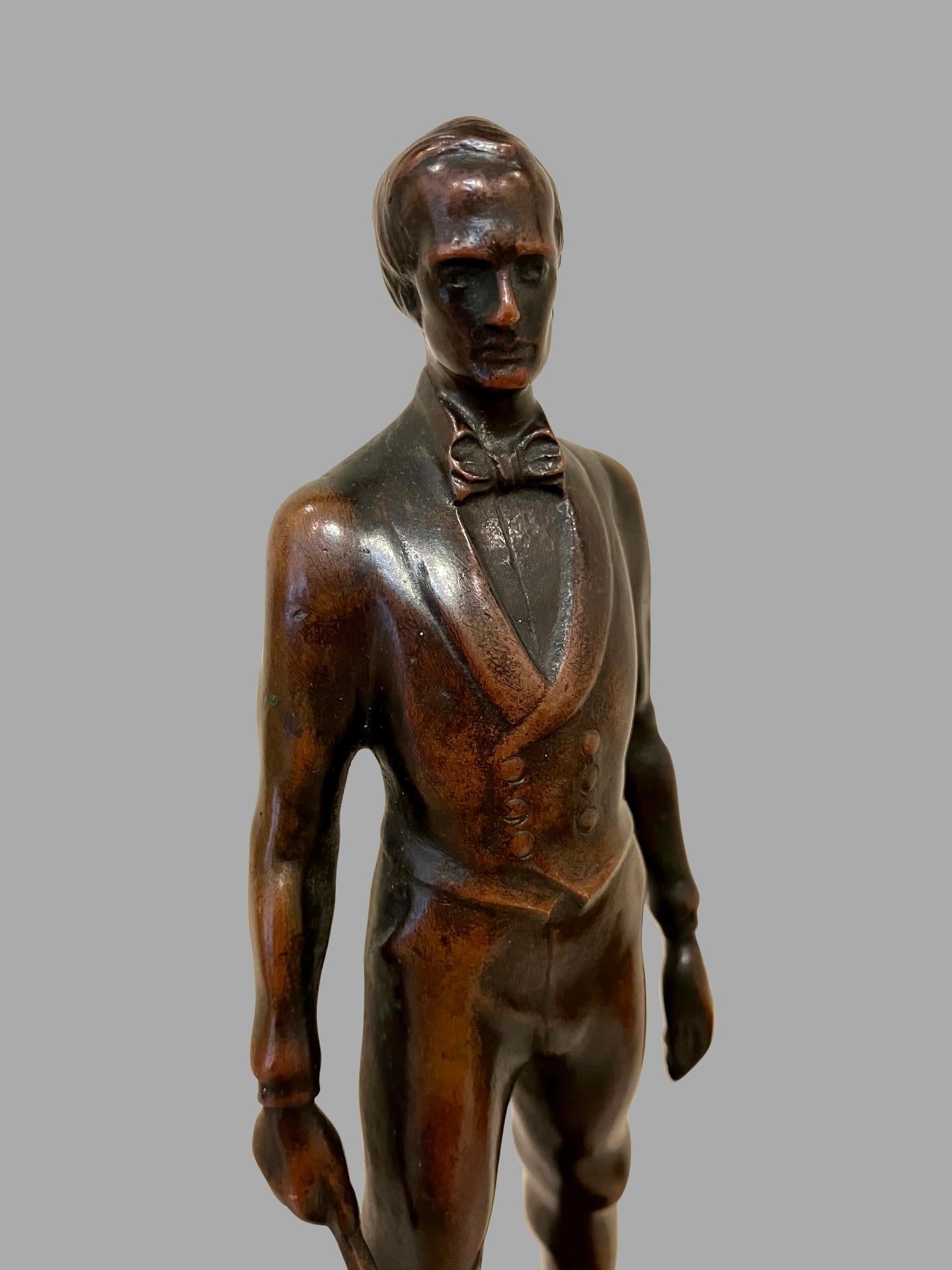 Un piccolo bronzo raffigurante un uomo in piedi in abiti formali che impugna una bacchetta in vendita 1