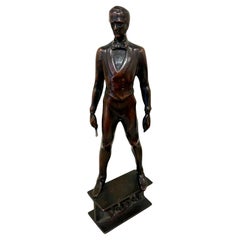 A Small Bronze of a Standing Man in Formal Attire Holding a Baton