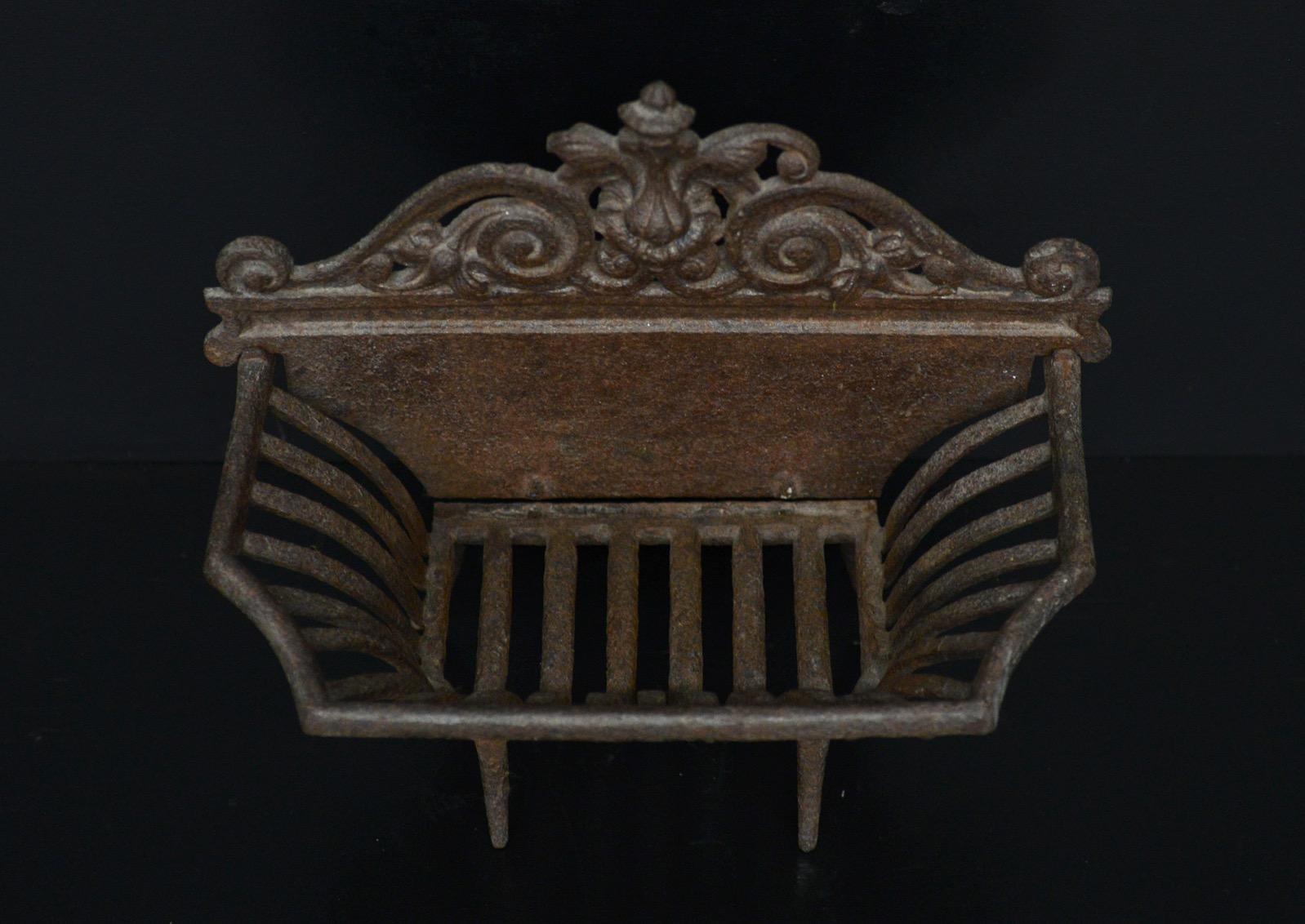 A petite cast iron firegrate. The shaped burning area with delicate legs and decorative cast iron back behind. English, 20th century. Could be polished if required.

Width At Front:	381 mm      	15