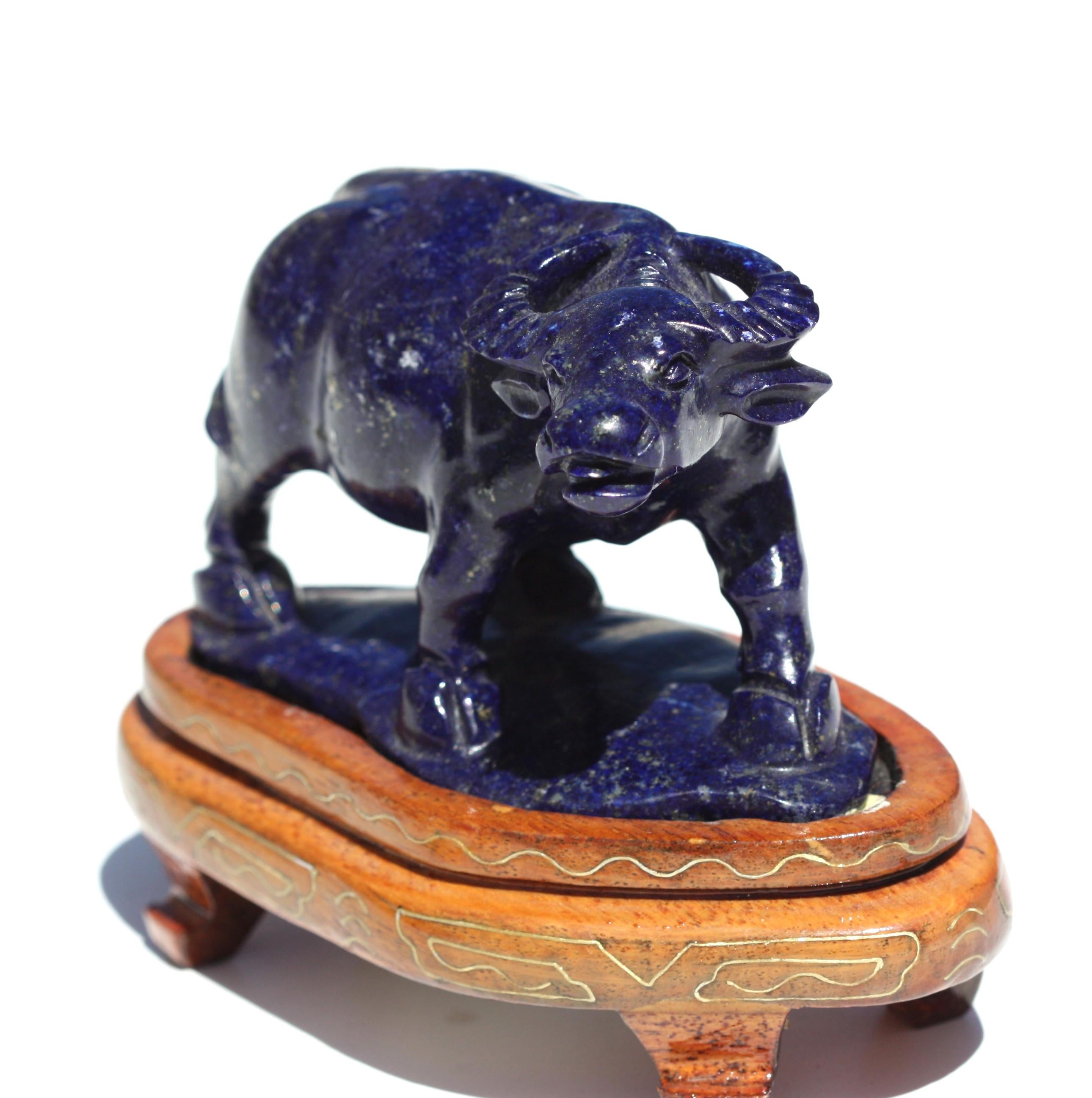 A small Chinese carved Lapis-Lazuli figure of a water buffalo
Naturalistically carved as a muscular buffalo sturdily standing on four cloven feet, the raised head turned to the right, its dignified features depicted with alert round eyes and a