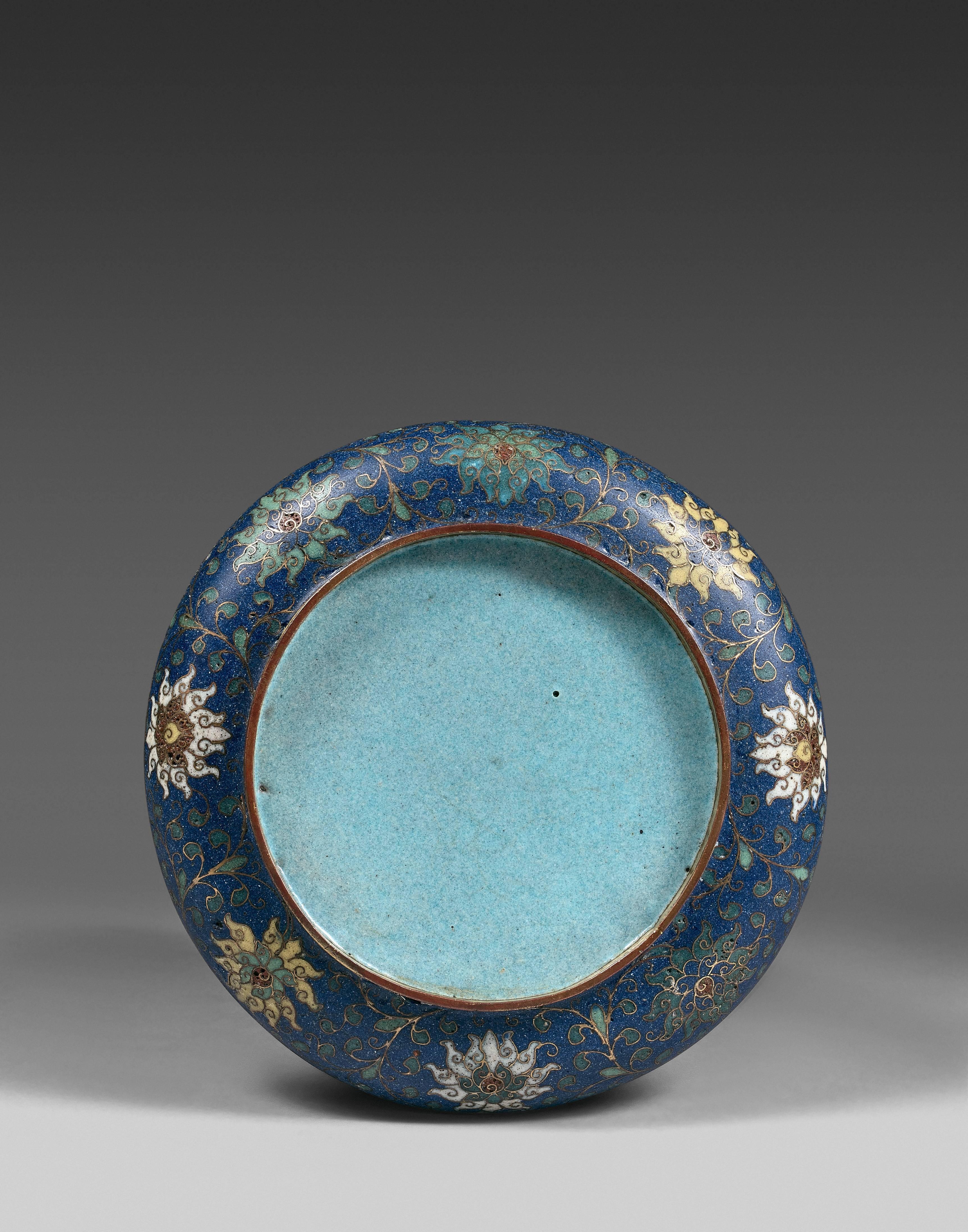 The small round dish with a short round foot, the cavetto in light blue enamel, the centre of the dish with archaistic chilong dragons encircling an unusual vermillion 'shou' character. The back of the dish with lotus flowers and scrolls on deep