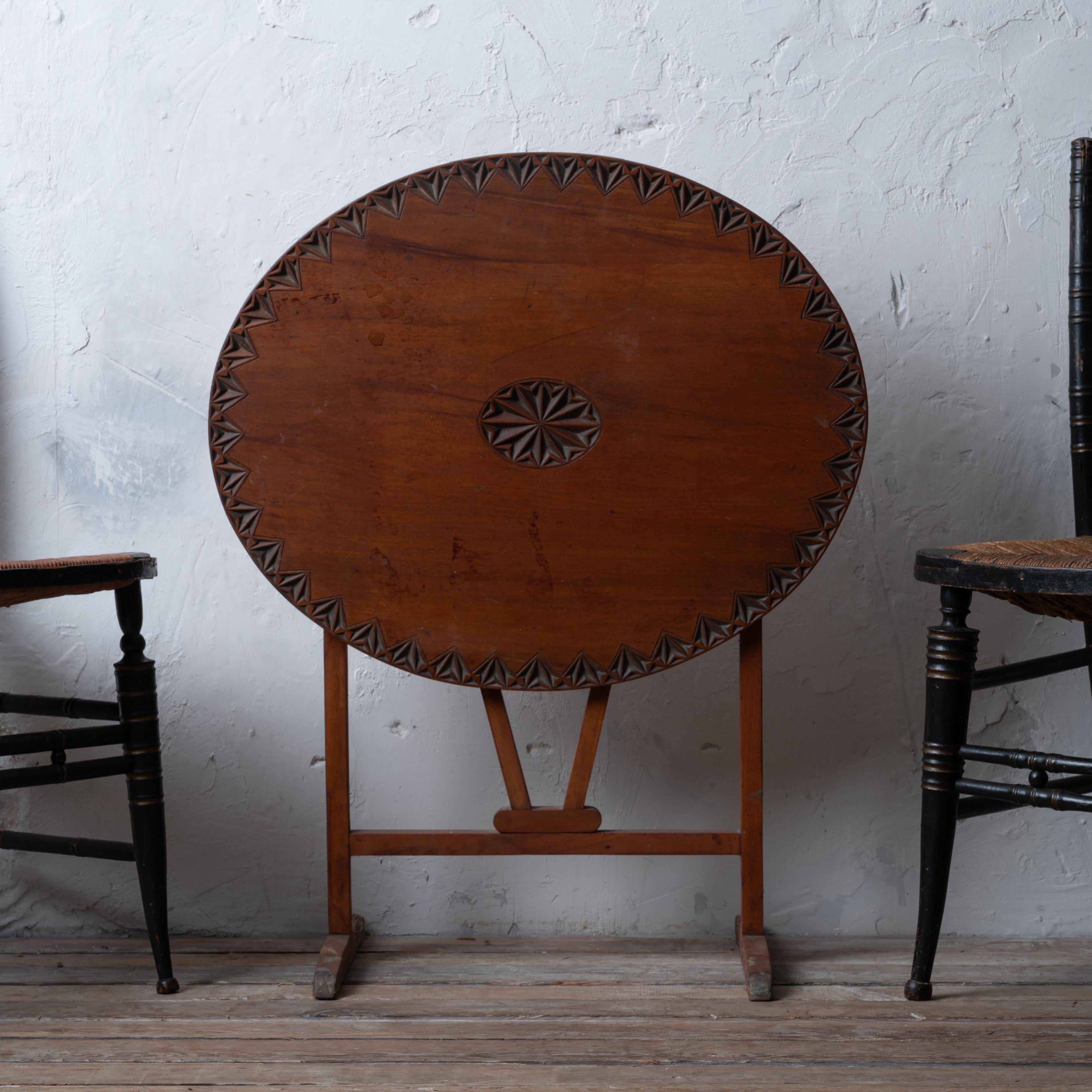 A chip-carved walnut tilt-top wine tasting table of light weight and small proportion, late 19th century.   

26 ½ inches wide by 22 inches deep by 24 ½ inches tall; 33 ½ inches tall upright

