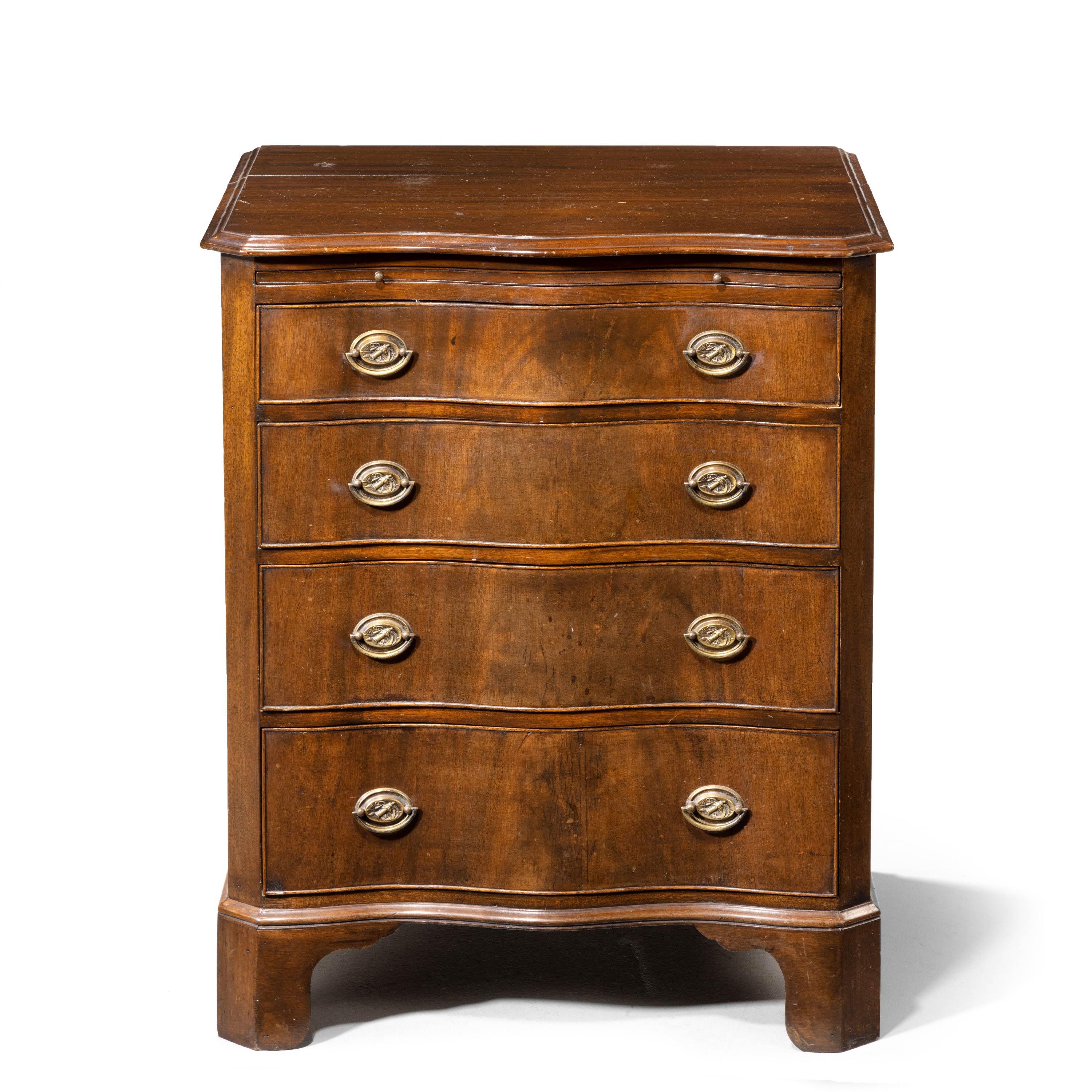 A very pretty, small, mahogany serpentine chest of drawers. Including a brushing slide, canted corners, original feet and with original oval plate handles.
  