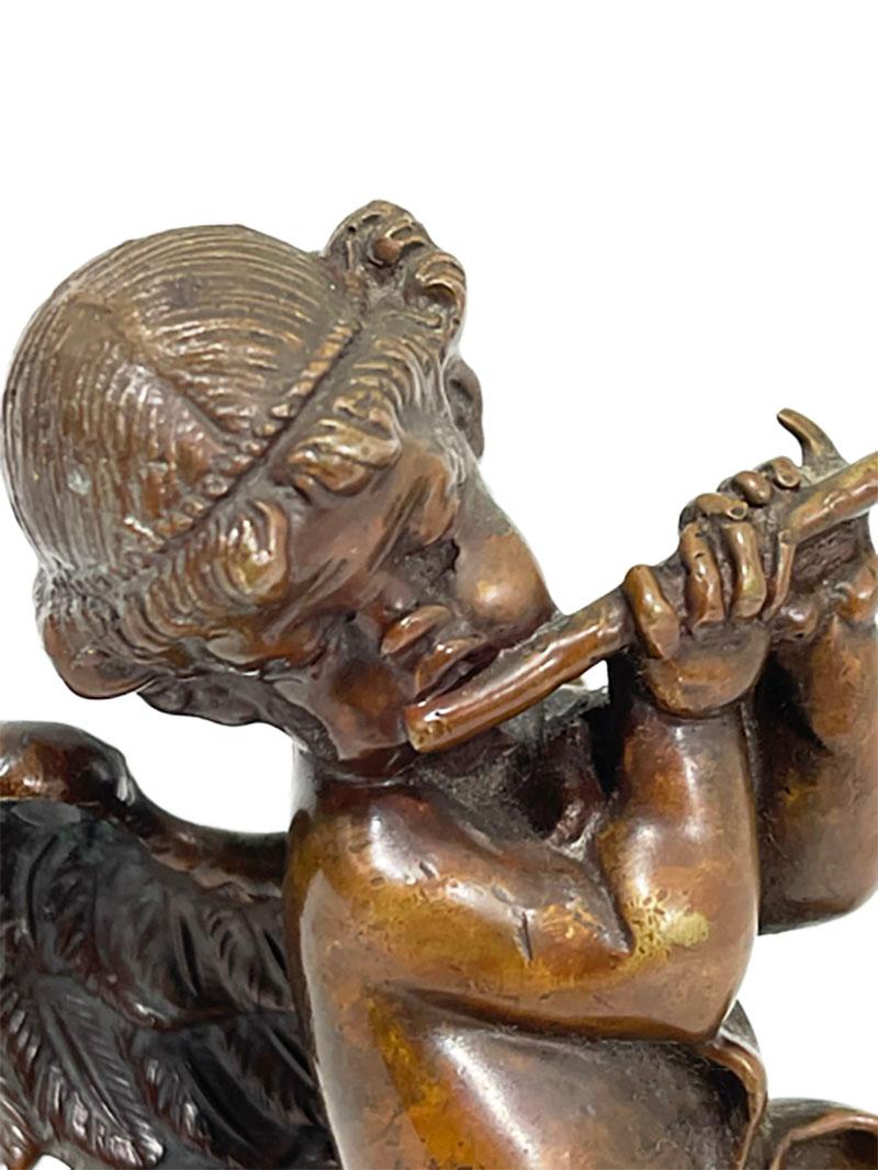 A small French 19th Century bronze statuette of a putti 

A small French bronze statuette of a putti playing the flute standing on a cloud, dancing with a ribbon in his arms. The bronze stands on an onyx base. Numbered with 61., impressed in