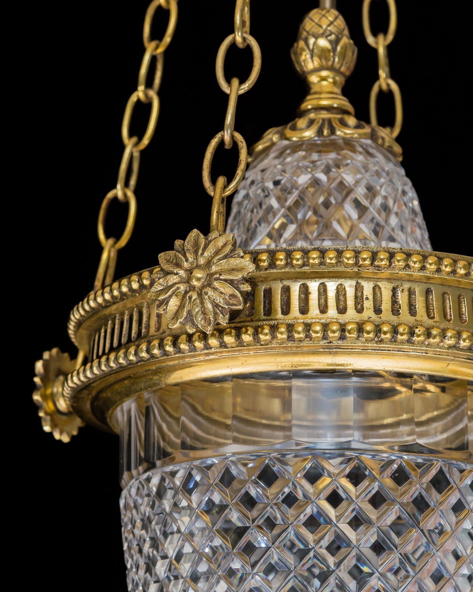 A great quality lantern of urn form, the glass cut with flat diamonds, mounted by gilt lacquered foliated metalwork suspended upon four chains.