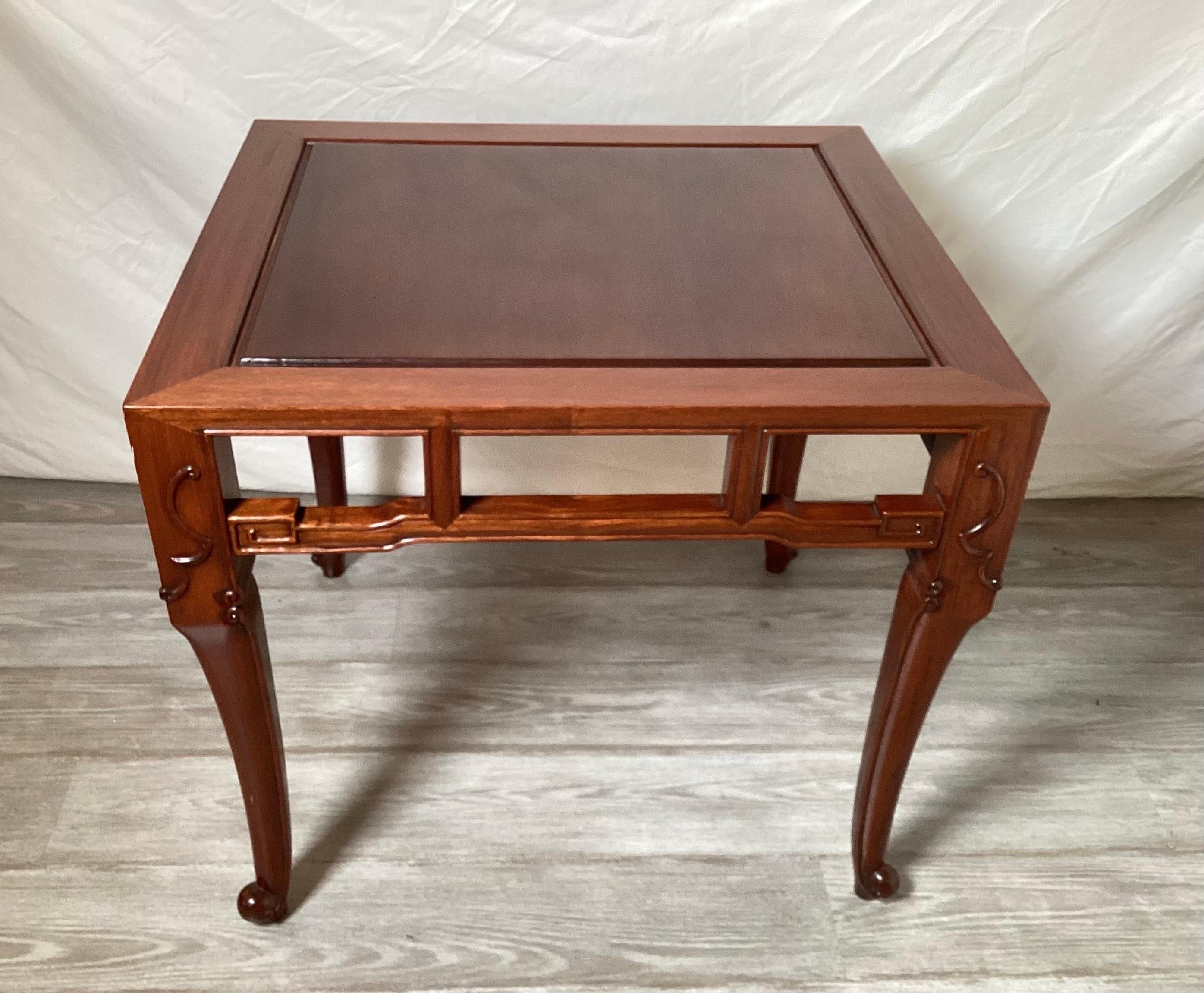 Elegant and simple hand carved Chinese hardwood table with beautifully detailed apron. The table is 24 deep, 25 wide, and 27 high. The top is intentionally a bit darker than the legs which also have a delicate carved detail at the top.
