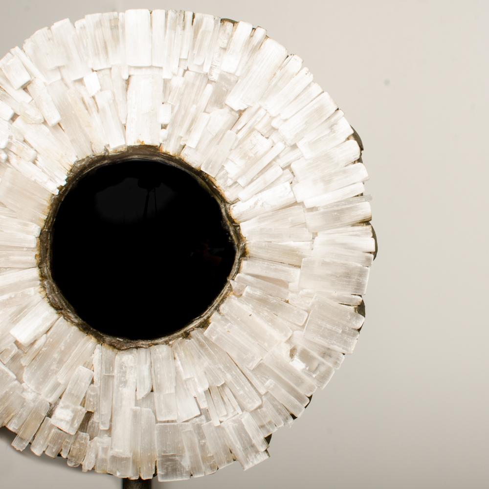 A small iron and stone table top starburst convex mirror, contemporary.
