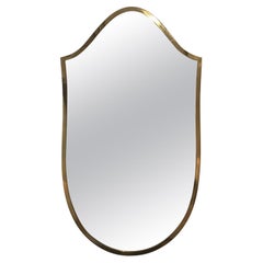 A small Italian 1950s brass shield shaped mirror
