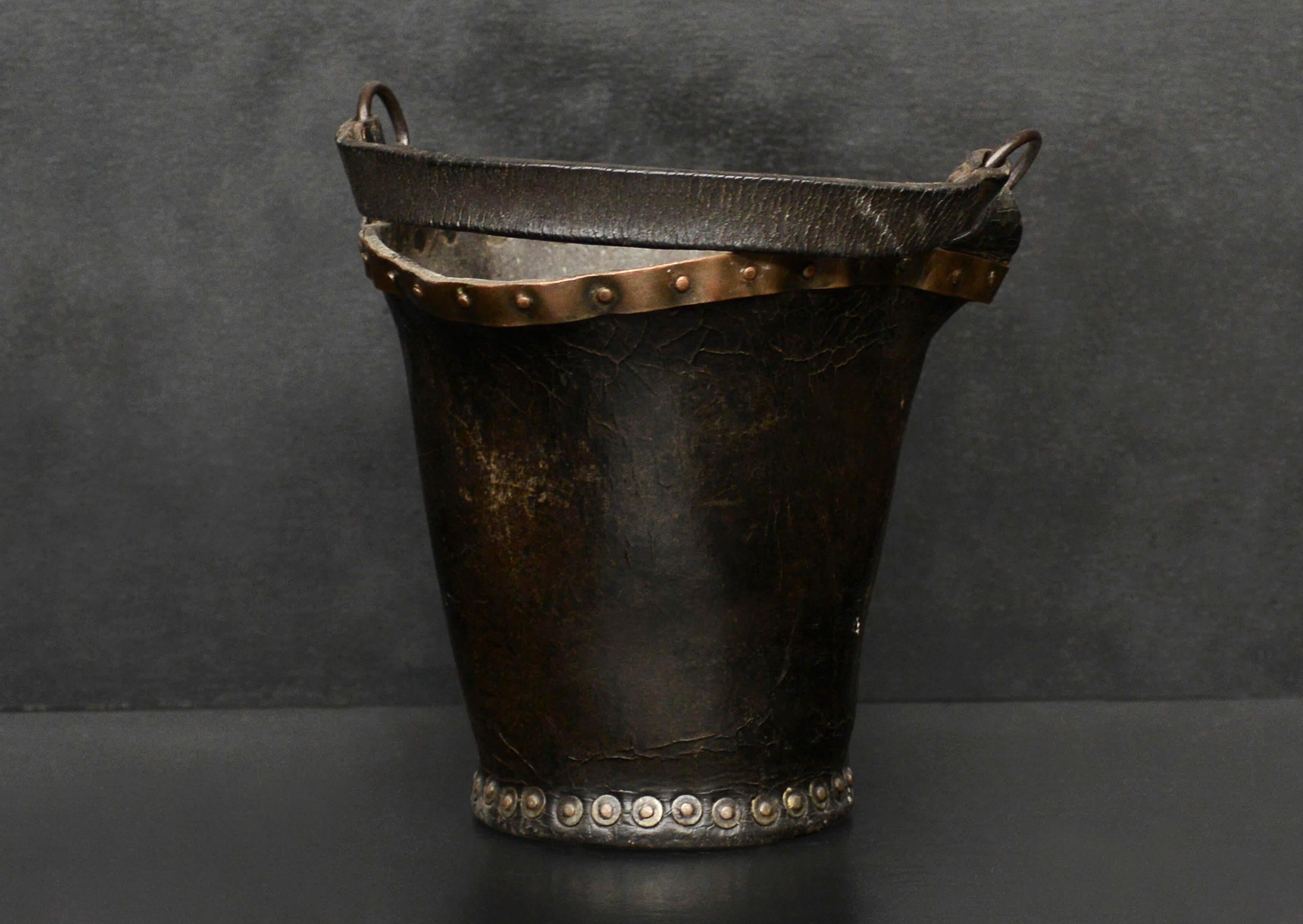 A small scale leather coal bucket with copper band and studding. English, circa 1900.

Height:	270 mm      	10 ⅝