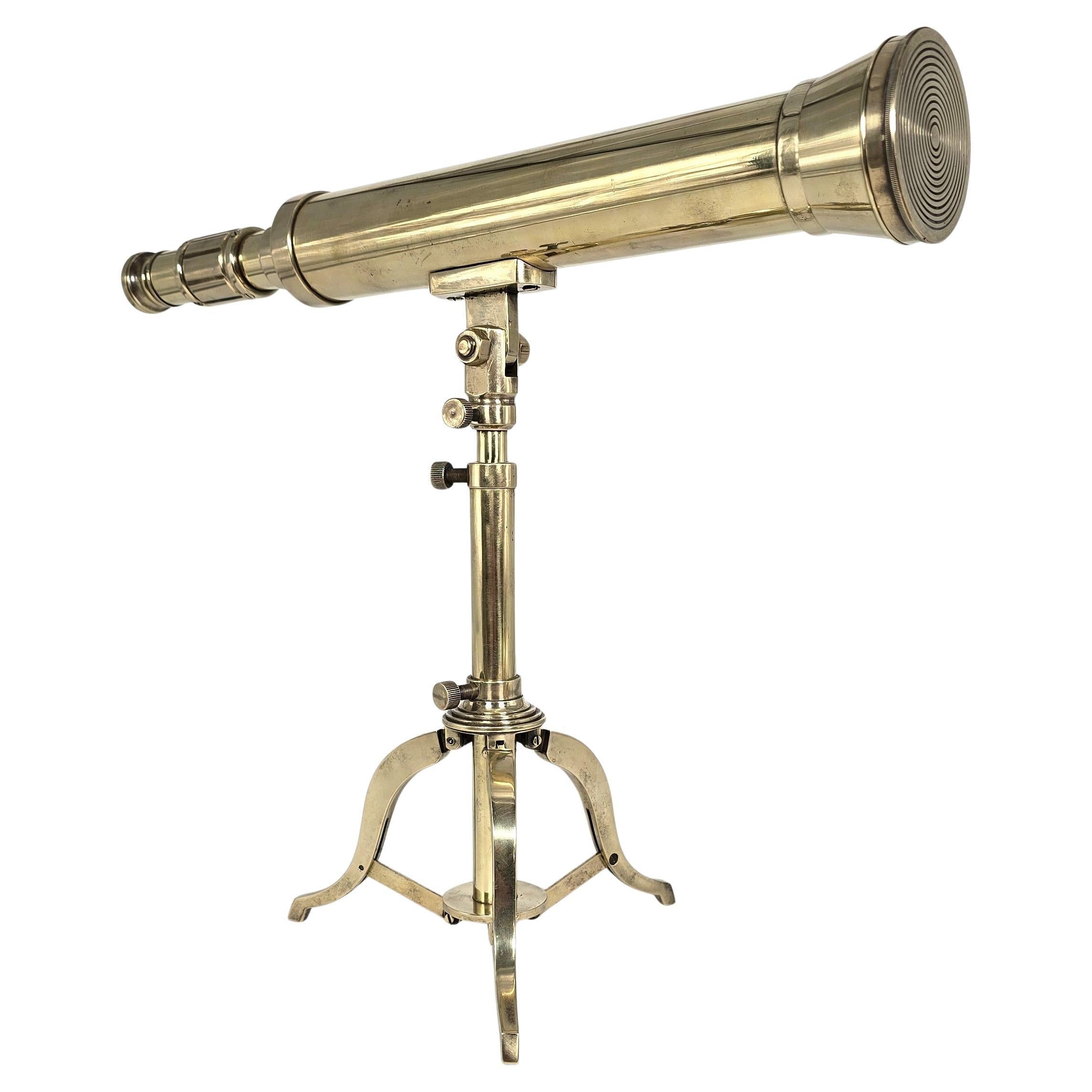 A small mid 19th C brass telescope with an original folding brass tripod stand