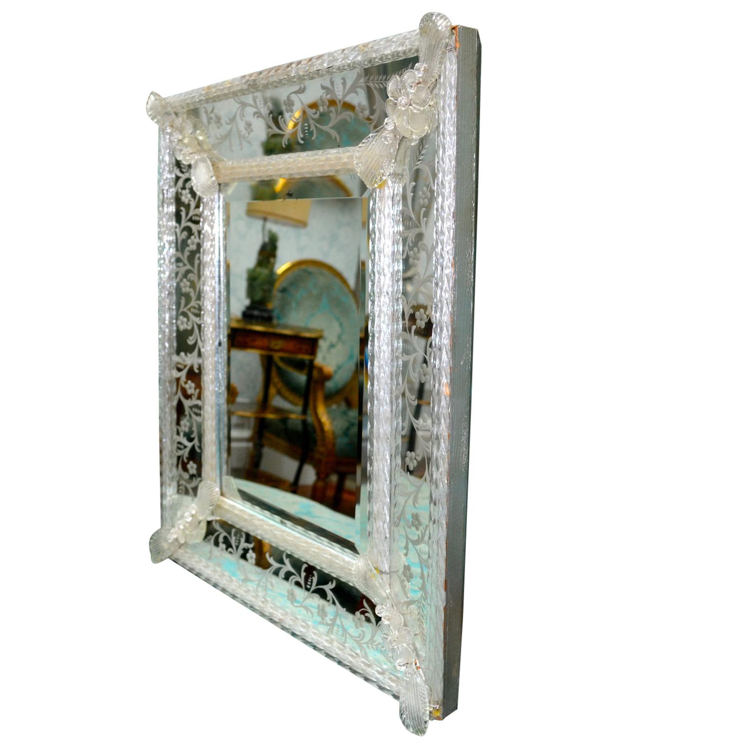 A rectangular ‘cushion’ style Venetian mirror; the four sloped sides around the beveled mirror have all-over floral engraving, all sections framed with clear crystal rods.

 