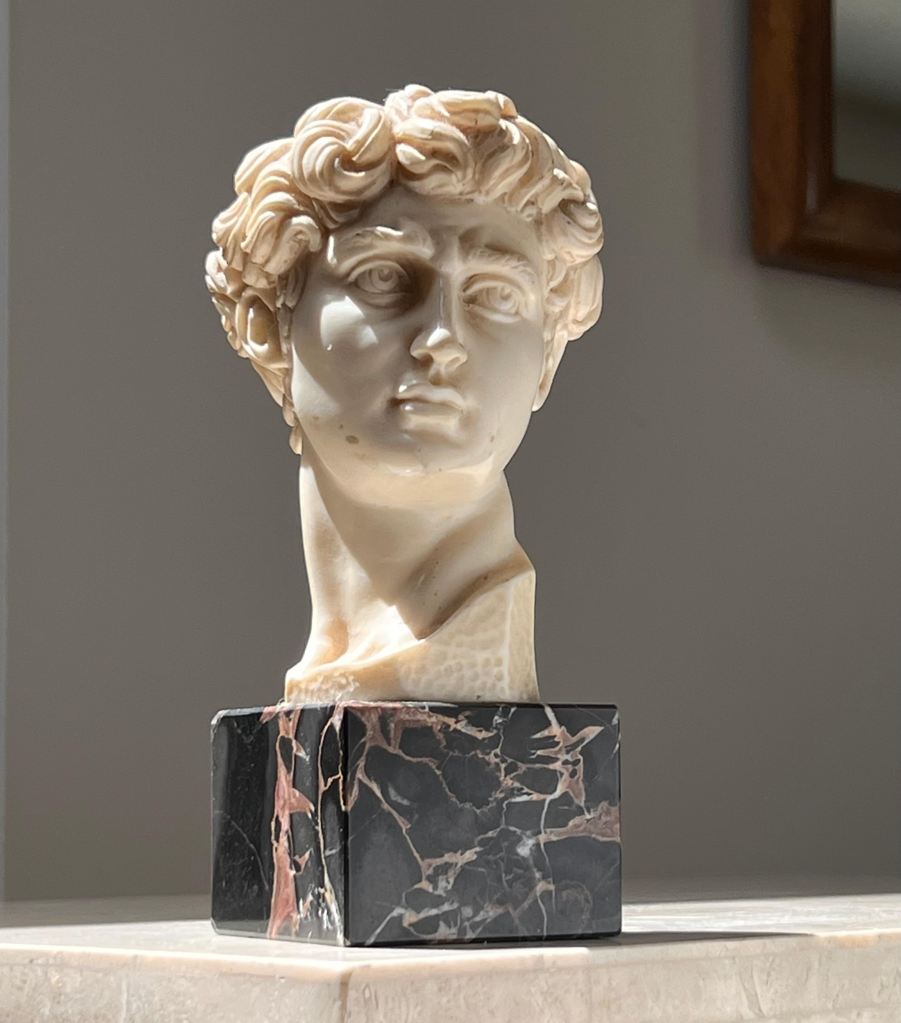 Buste du David en résine sculpté à la main par G. Ruggeri, signé, Italie, 20e siècle. Le buste repose sur un socle de marbre noir.