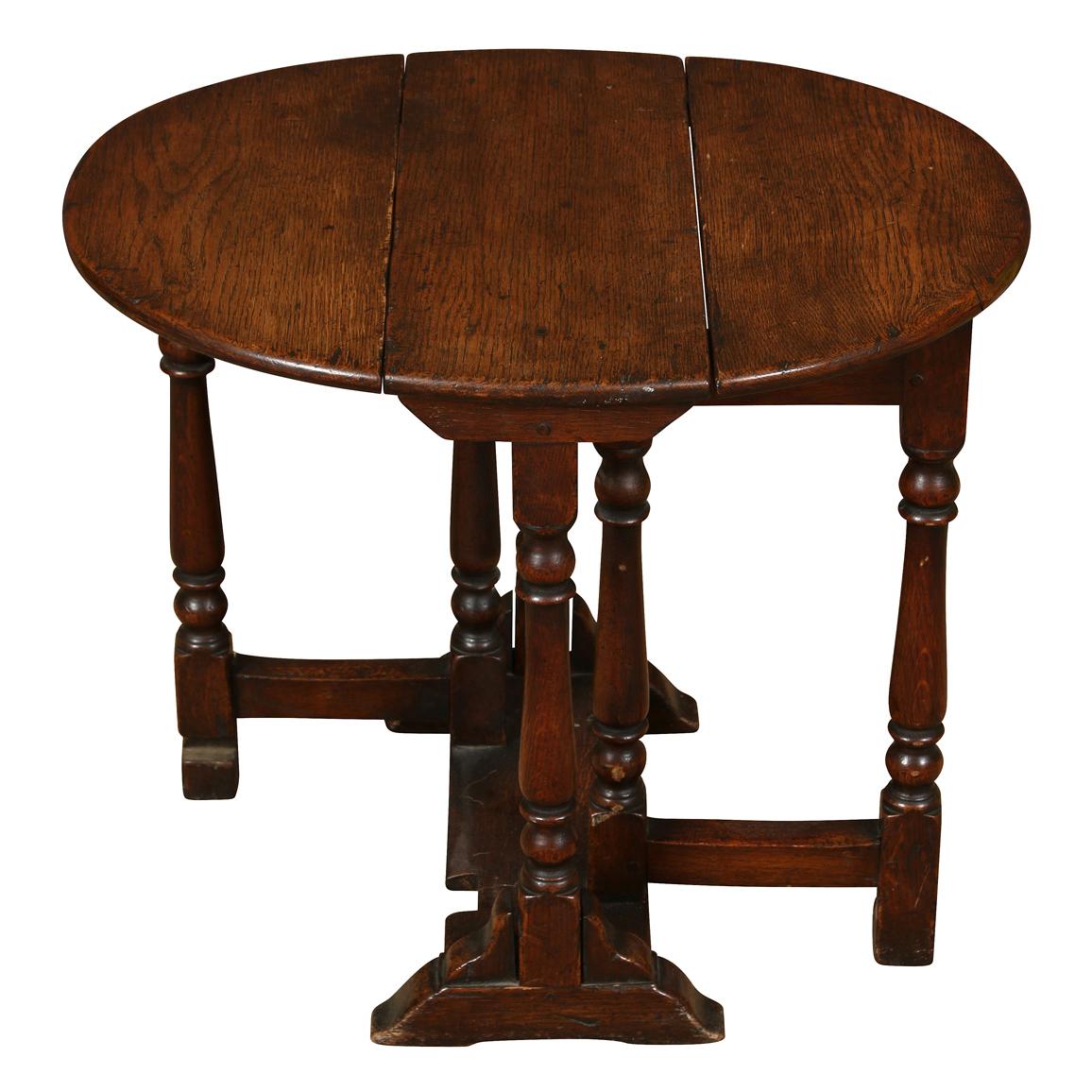 A charming small drop-leaf gate leg table in a dark oak.  Perfect for the side of a chair to hold a drink or books.
