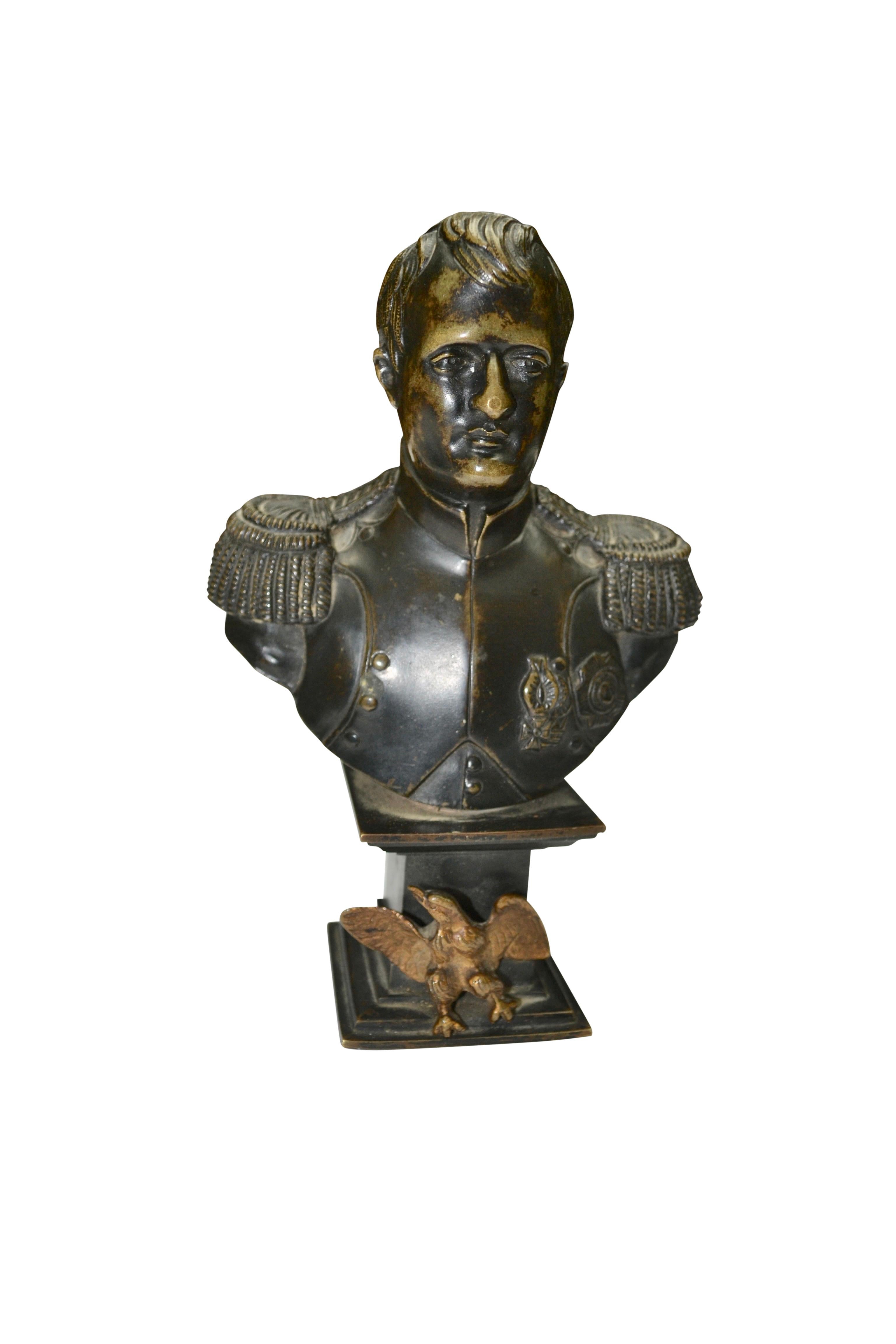 A small bronze bust of Napoleon in military uniform raised on square bronze plinth fronted by a gilt bronze eagle.
  