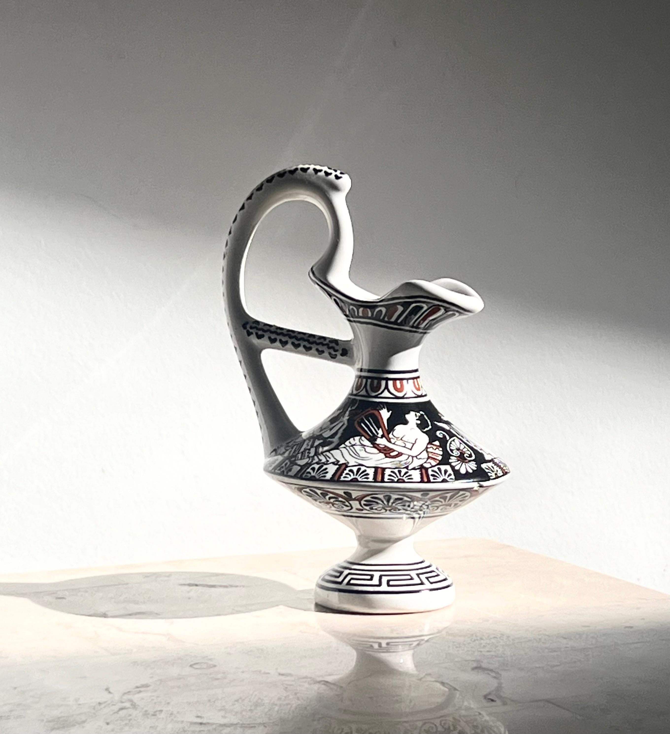 A small ceramic pitcher featuring Ancient Greek motif - « Young Men and Girls Banqueting » - from circa 480 BC, made in Greece probably 20th century, signed by artist, and was once sold in the Musée du Louvre in Paris, as stated rather thoroughly on