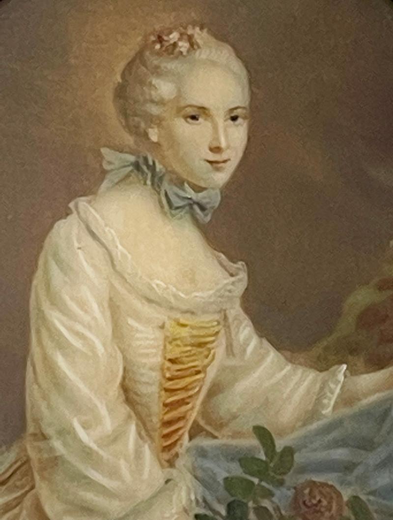 Ein kleines Porträt einer Frau in einem ovalen Bronzerahmen, 19. Jahrhundert 

Ein ovales Porträt einer sitzenden Frau mit weißem Stoffmieder und blau gestreiftem Rock mit Blumen in der linken Hand in einem ovalen kleinen zerbrechlichen Rahmen