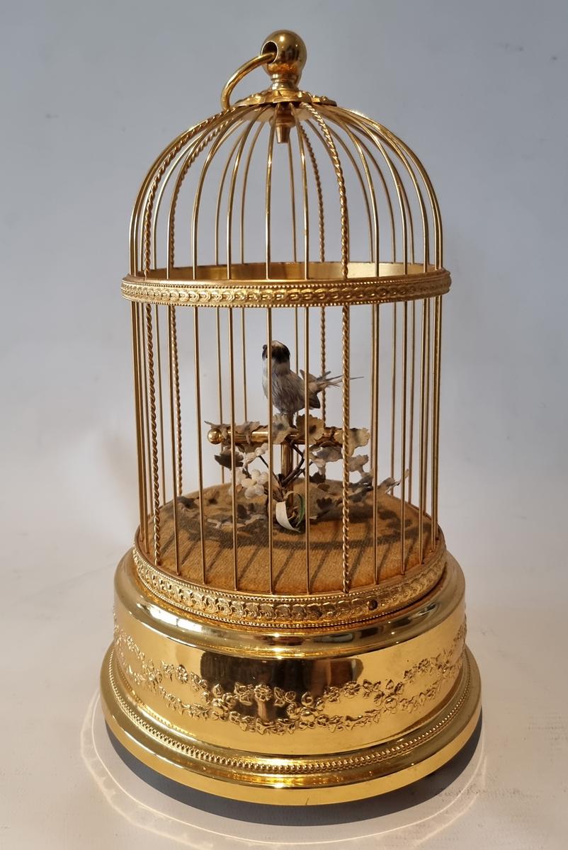 A small size singing bird cage by Reuge, with intermittent and continuous action settings. When wound and the start/stop lever slid to full position, the perched bird sings the jolly and melodic continuous phases, perfectly synchronizing beak, head