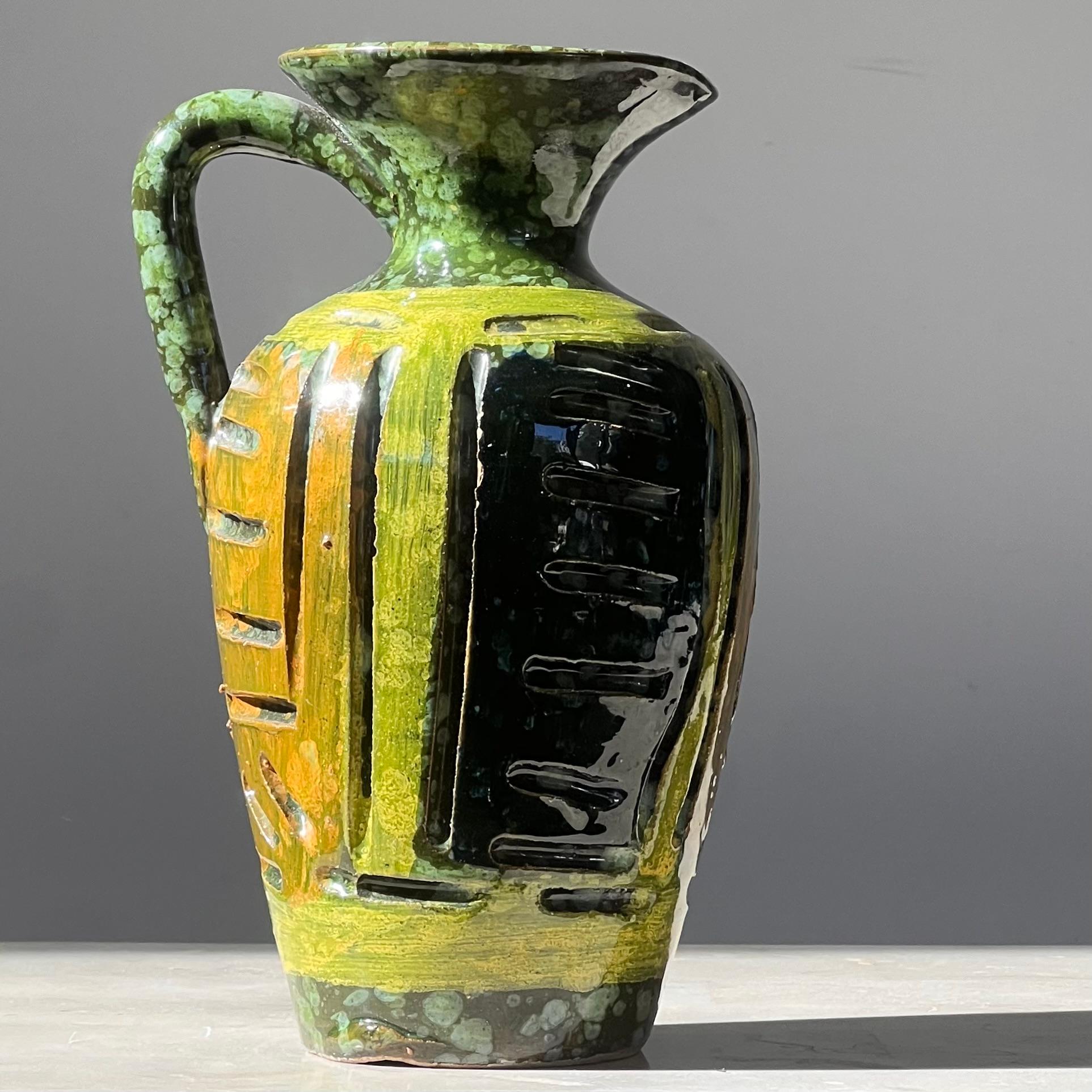 Jarra de cerámica moderna de mediados de siglo, según Guido Gambone, hacia 1960. En tonos pino, chartreuse y mostaza, y firmado en el reverso. 