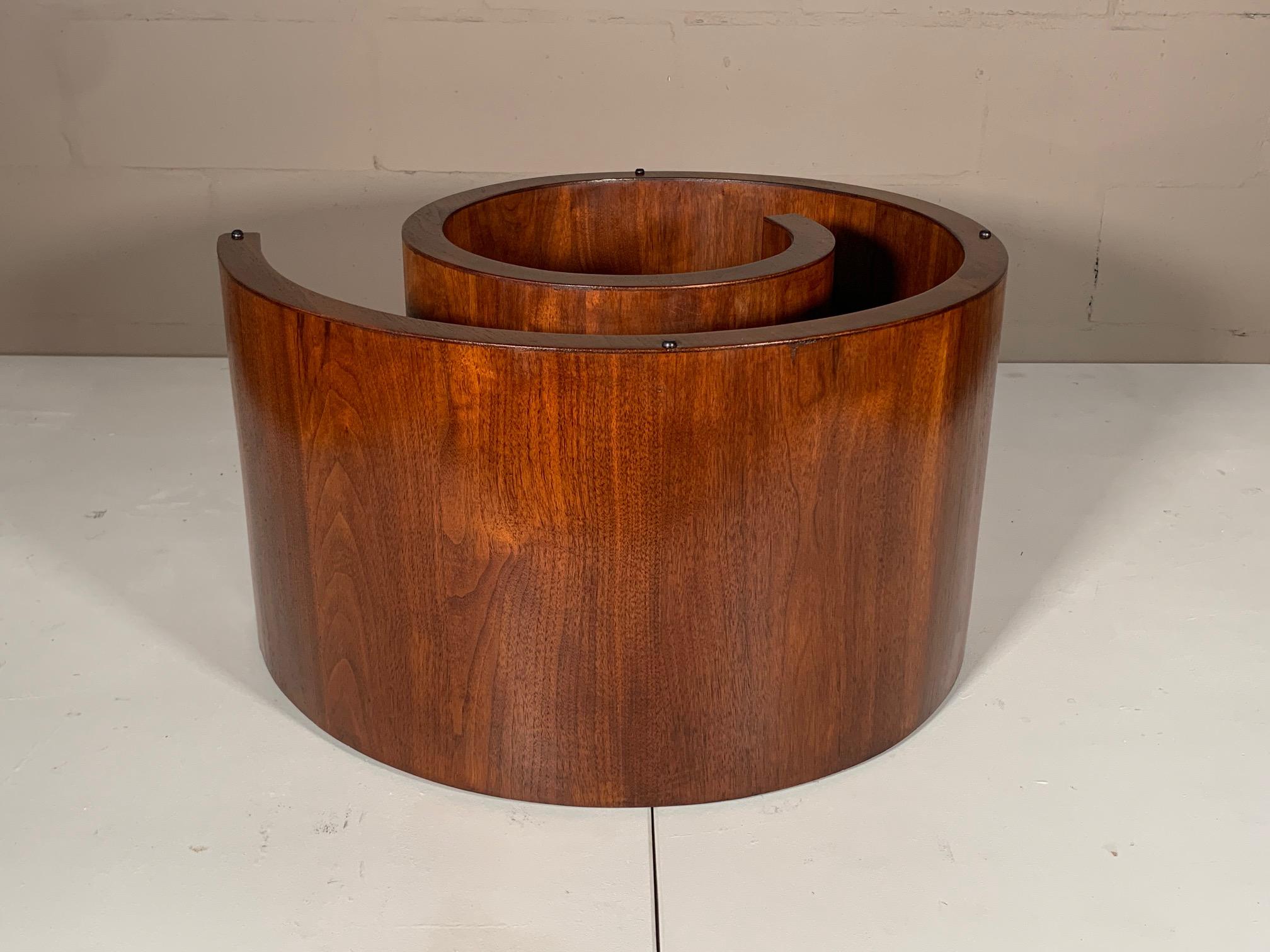 An unusual snail shaped coffee table, in the style of Selig, circa 1960s. Walnut with original glass.