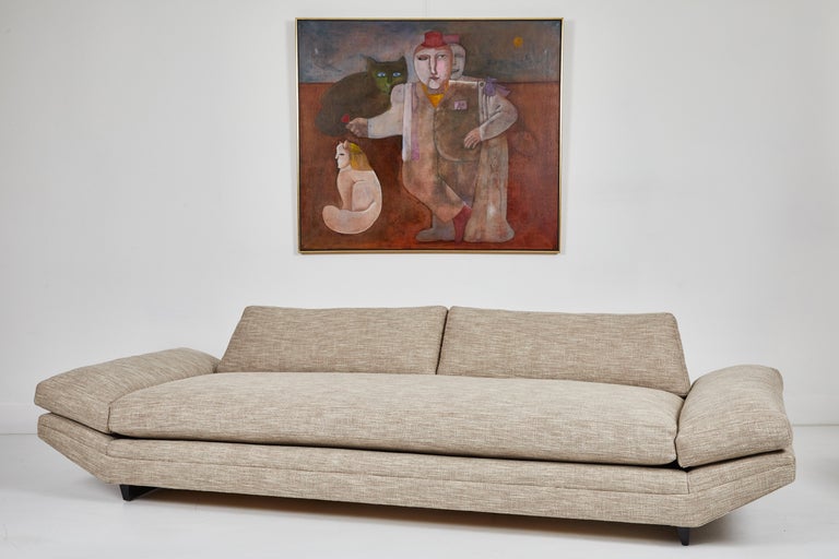 This is a wonderful example of a mid century modern sofa. Designed by John Keal for Brown Saltman, the sofa is upholstered in a heathered beige linen blend fabric and sits on two espresso finished wood vertical runners. The sides of the sofa are