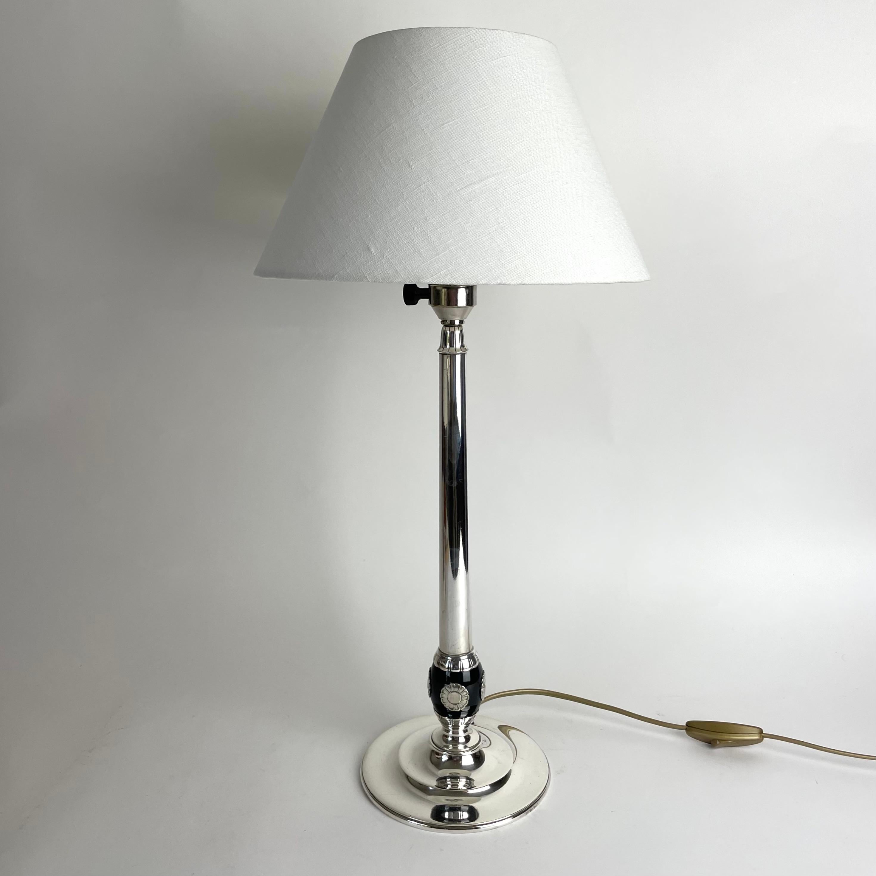 A sophisticated silver-plated Swedish Grace Table Lamp. Made in Sweden during the 1920s. Decorated with silver-plated flowers on black bakelite.


New rewired electricity and new lamp shade.


Wear consistent with age and use 