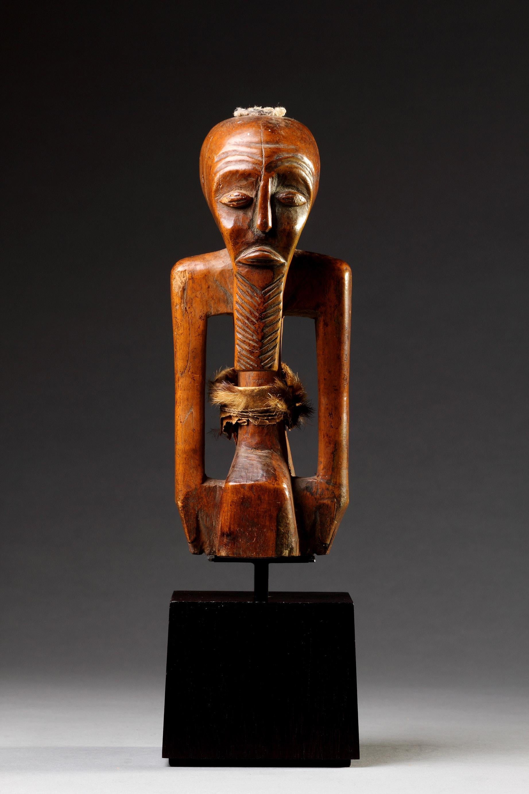 A South Eastern Congo, Zaire Songye Protective Fetish Figure ‘Nkishi’ of Geometric Form the arms placed to the side
A plug of fetish material in the head cavity a strip of old hide and fur around the waist
Old smooth crusted patination
19th Century