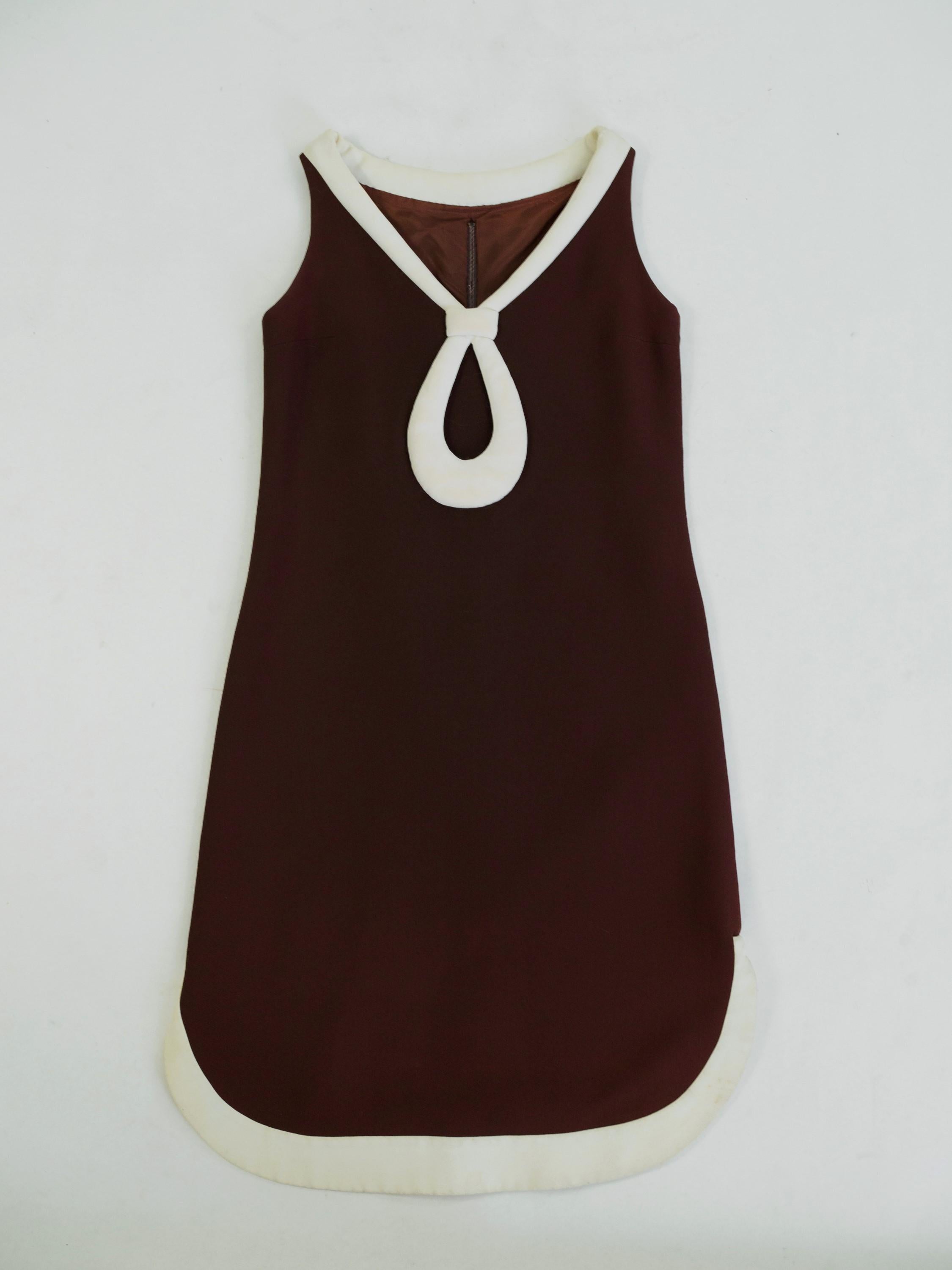 Circa 1970/1975

France

Astonishing dress from the futuristic or Space Age period by Pierre Cardin dating from the early 1970s. Sleeveless pinafore dress in thick chocolate jersey. Large pointed neckline underlined by a large cream bead in the