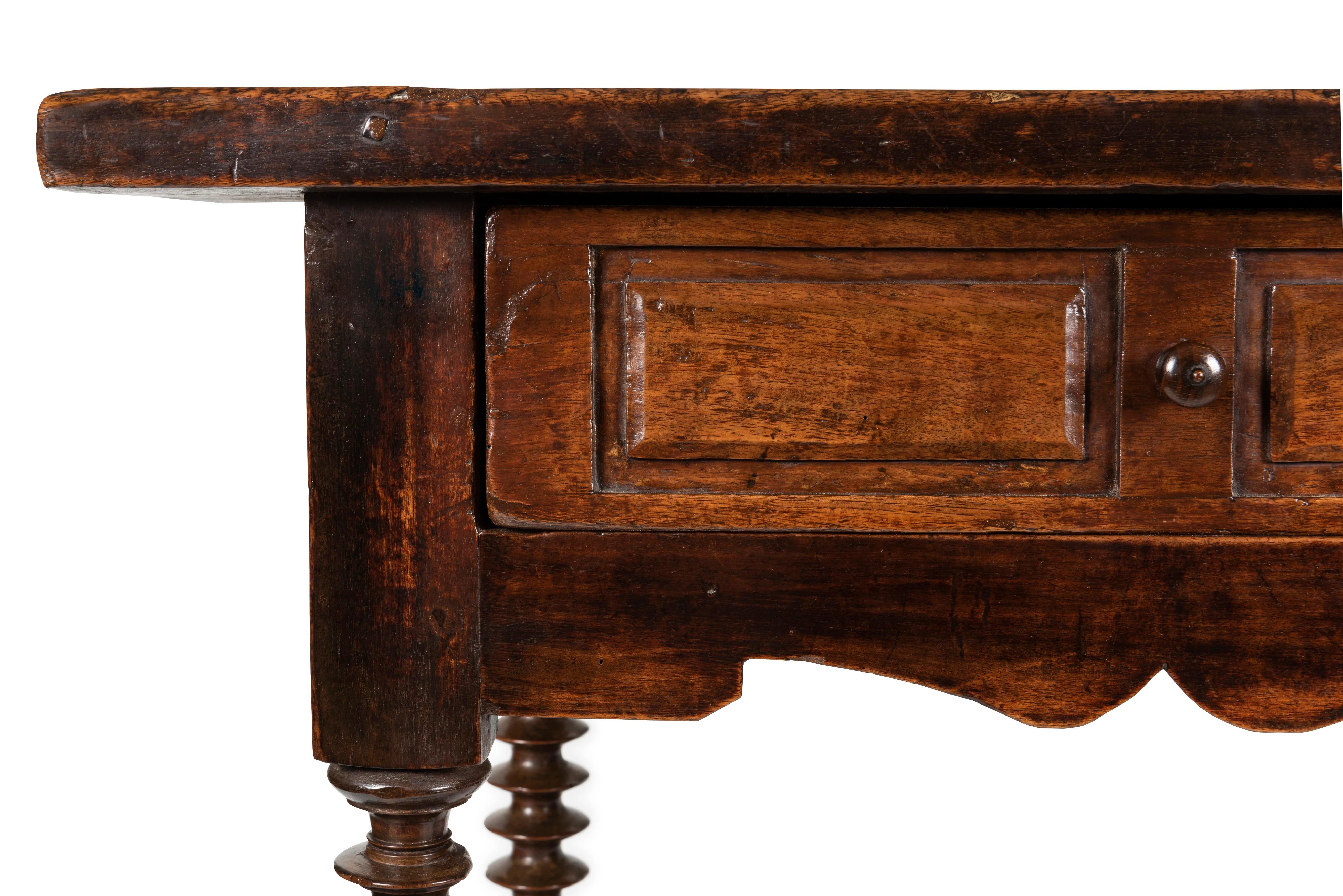 A Spanish 17th Century Style Walnut Side Table, 19th Century

Provenance:  
Private Australian Collection.

Description:
With plank top over frieze of single drawer, centred by turned timber handle and bronze cartouche shaped escutcheon, to four
