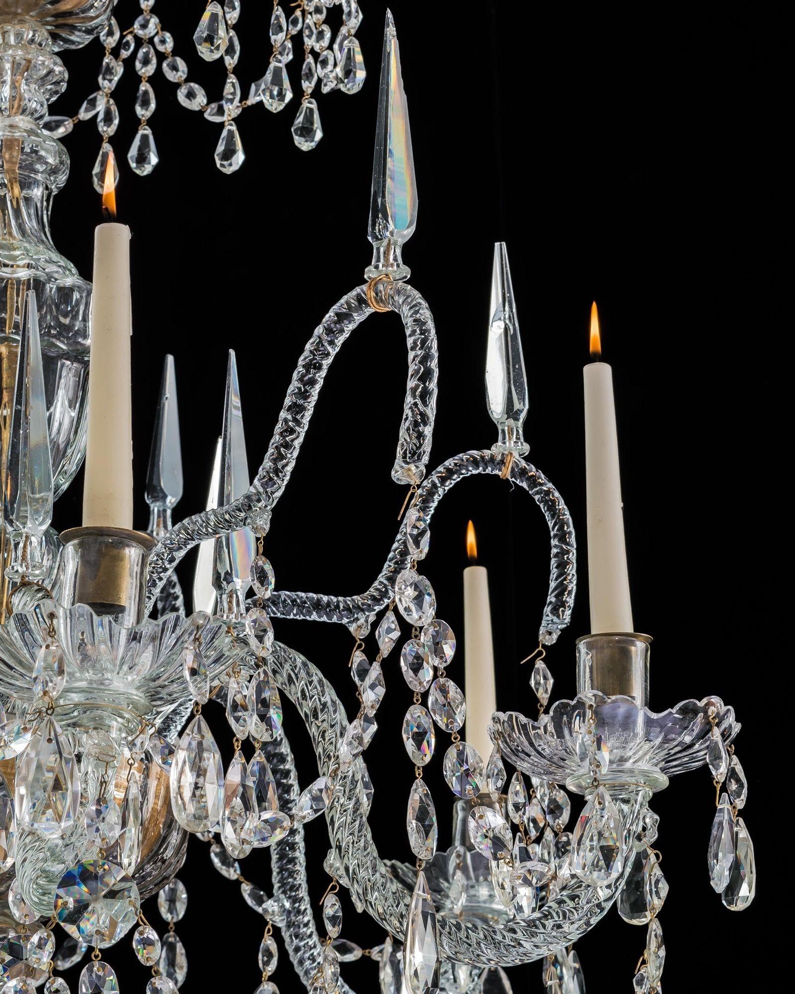 The blown ribbed stem with central urn supporting a draped corona of rope twist canes mounted with foliate finals. The receiver bowl issuing six large canes mounted with spires and drapery, and six scroll candle arms and drip pans, the chandelier
