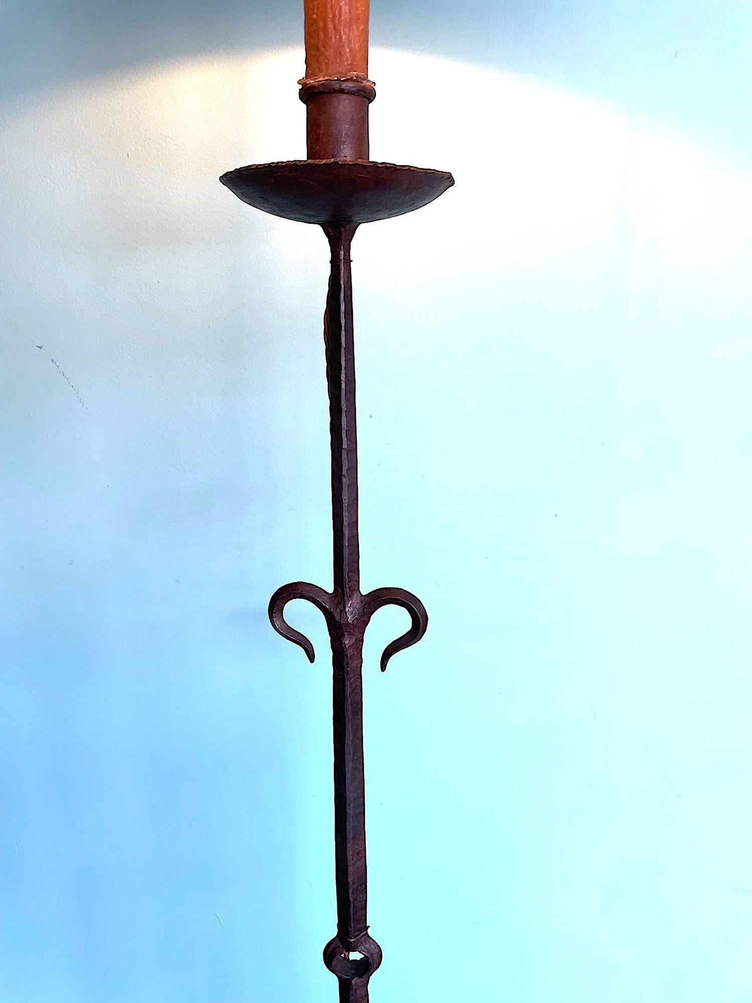 A Spanish 1950s wrought iron floor lamp with detailed stem on three legged hammered base and new bespoke natural shade. Re wired with new brass fitting, antique gold cord flex and PAT tested.