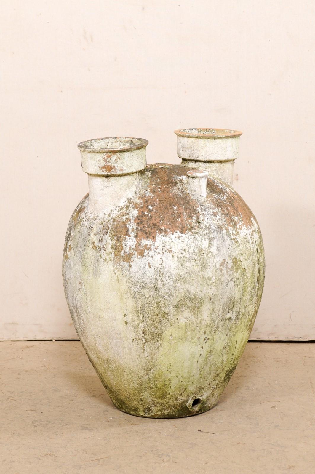 A Spanish large-sized terracotta vessel with fabulous patina from the turn of the 19th and 20th century. This antique clay jar from Spain is nicely sized, standing approximately 3 feet in height. Its rounded body is topped with a pair of larger