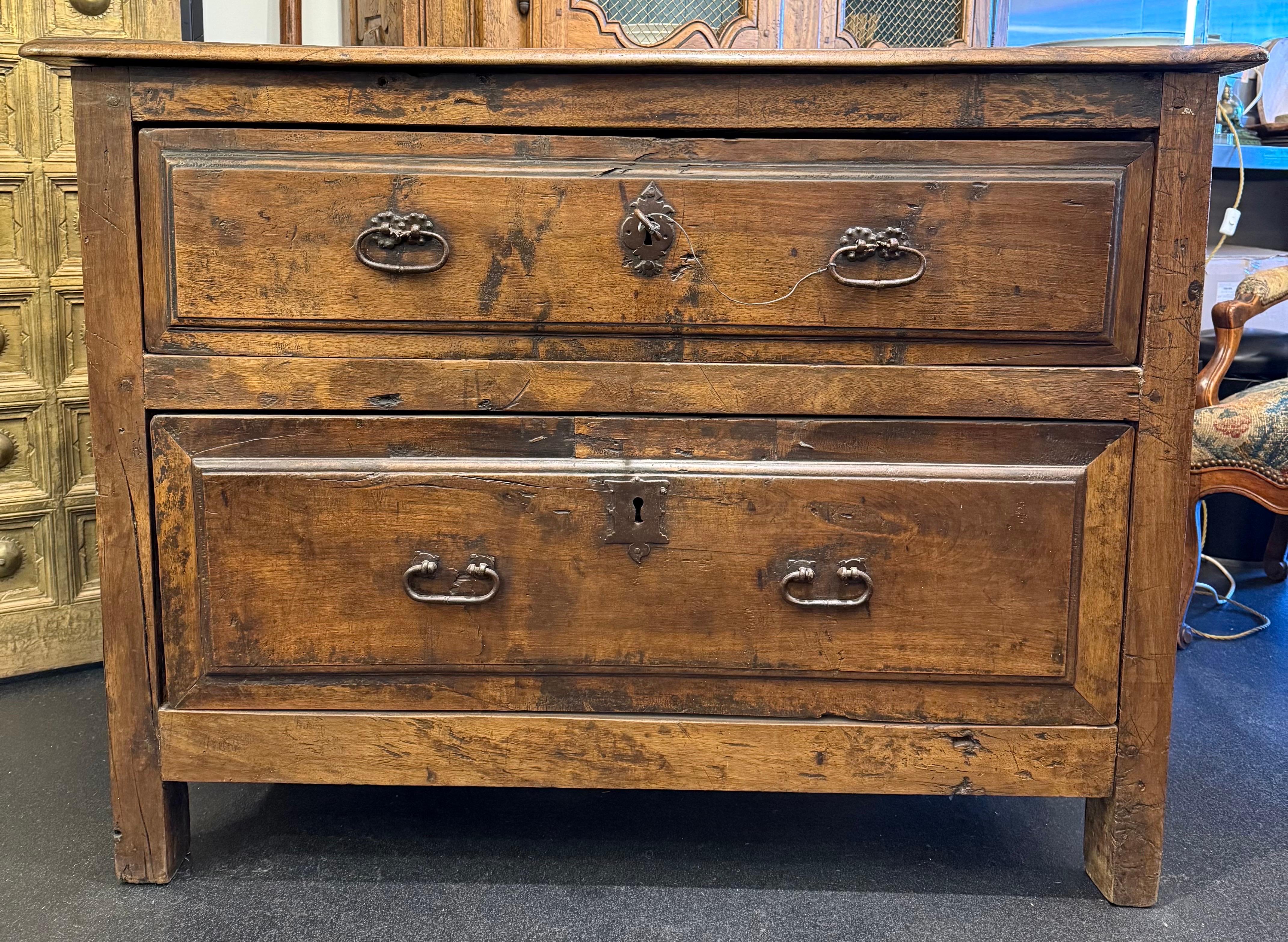 A Spanish Carlos II Walnut Chest of Drawers, 17th Century

Provenance: Christie's Melbourne, 2000.

Description: 
A rectangular plank top with some exposed rounded iron nail heads and a torus profile above two full length raised panel drawers, each