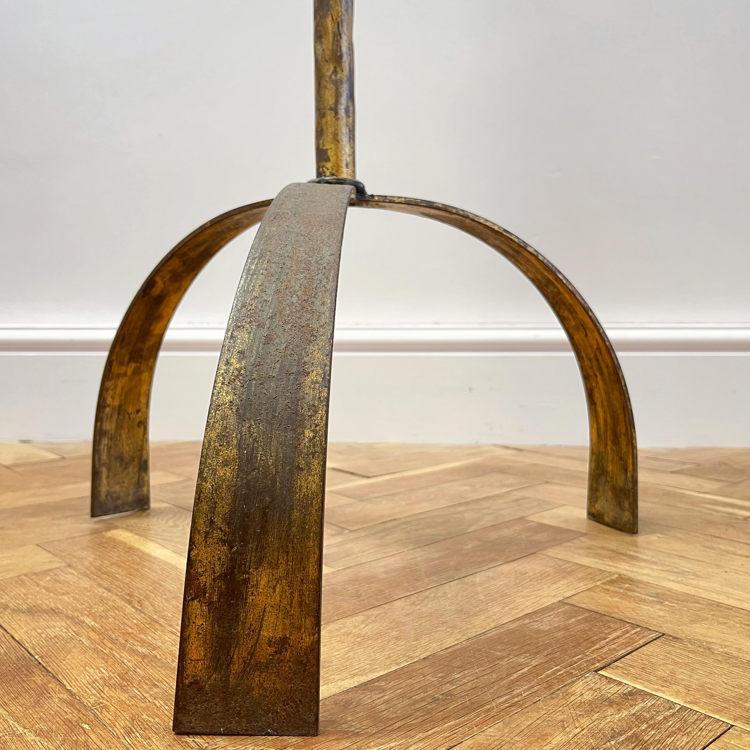 An unusual gilt iron floor lamp with two central pierced spheres resting on tripod legs, overall worn gilding and textured metal finish to shaft.

Spanish, c.1950

H to bulb holder 140 x W46 cms