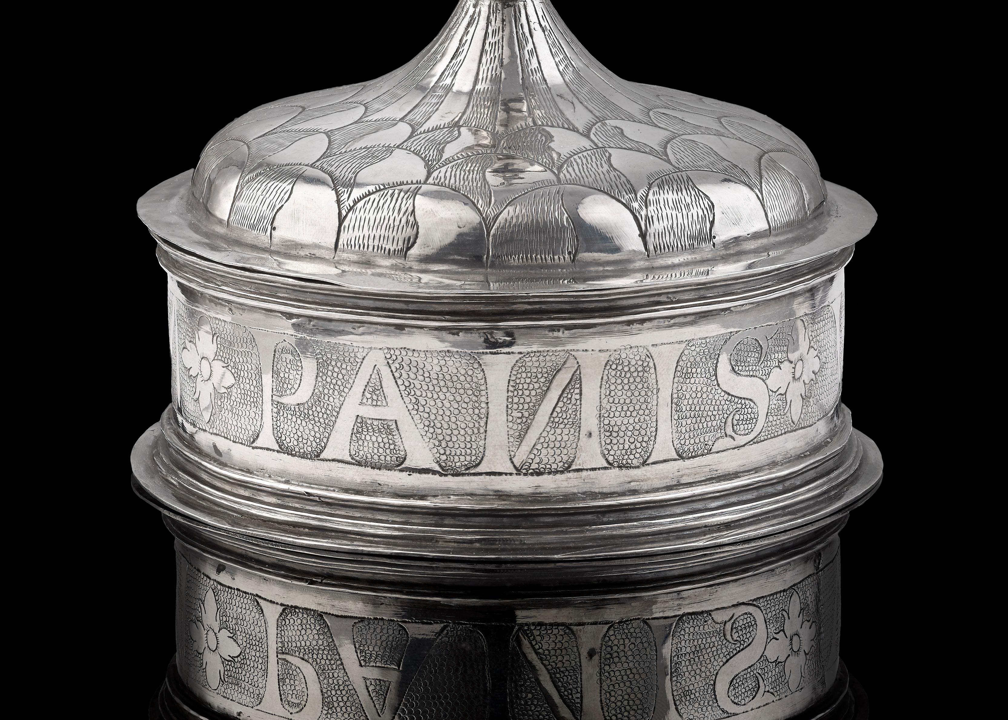 A Spanish silver Pyx, circa 1600, gilded inside and with maker's mark; engraved around the body with the words 'Ego Sum Panis Vie' (I am the bread of life); approx. 14 cms tall, and 9.8 cms in diameter across the base; weight is 5 1/2 ozs