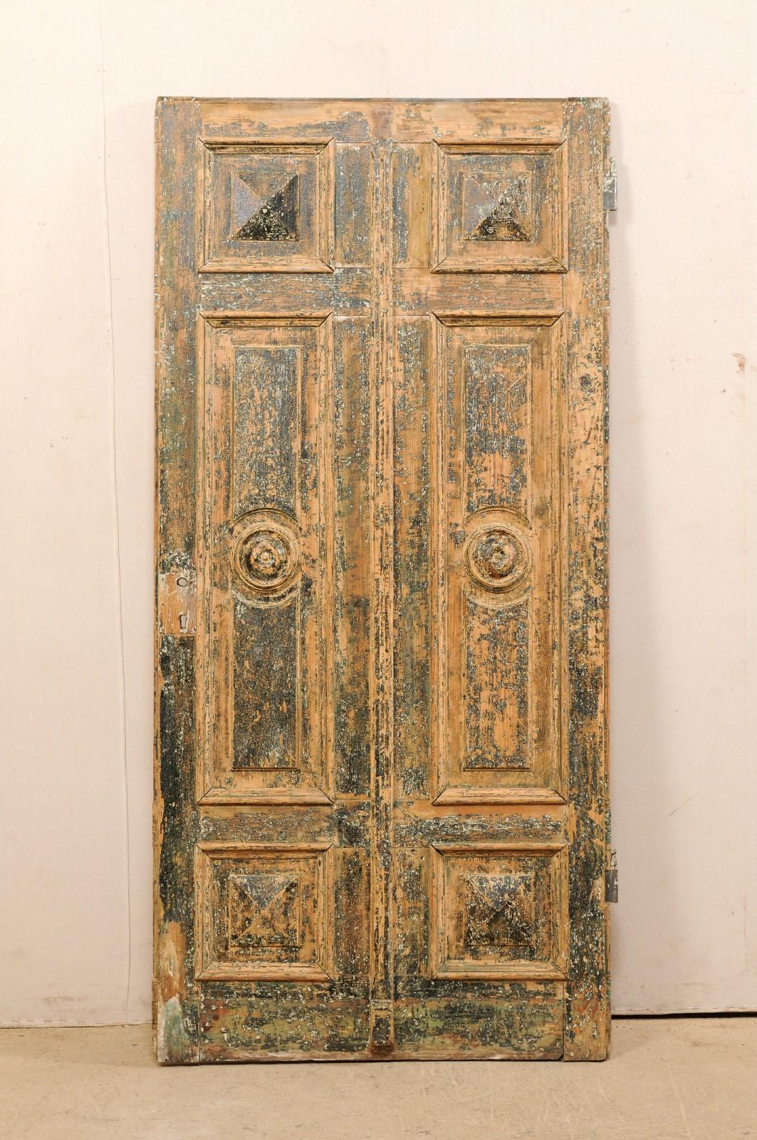A Spanish single door with decoratively-carved raised panels from the early 19th century. This lovely antique door from Spain features a six raised panel front, comprised of two rows of rectangular panels with squared panels at top and bottom, and a
