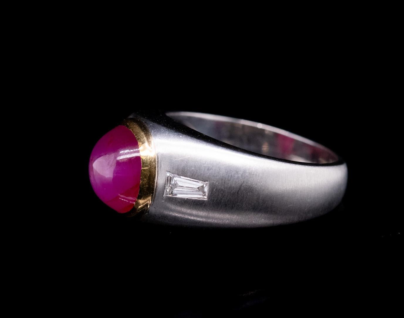 This 6.02ct Cabochon Star Ruby men's ring is set in 18k white and yellow gold 
with 2 side baguette diamonds accentuating the beauty of the center stone = 0.40cttw