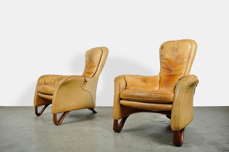 Special set of two armchairs with footstool, 20th century. The club armchairs have a beautiful ornate 