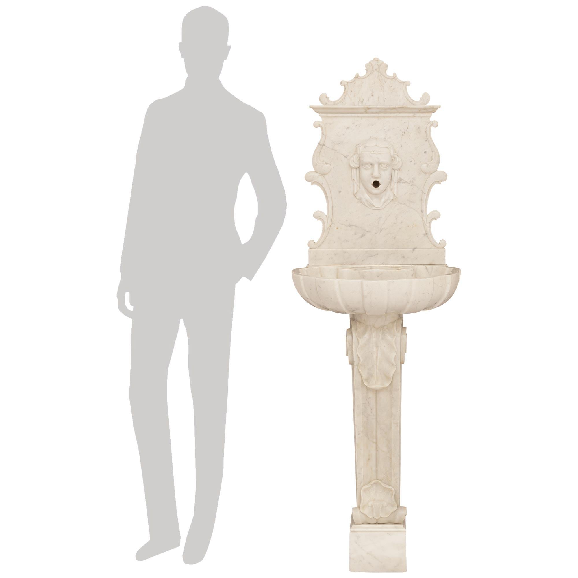 Une fontaine spectaculaire et de grande qualité en marbre blanc de Carrare de la Renaissance italienne du 19e siècle. Cette magnifique fontaine est surélevée par un socle rectangulaire supportant une colonne supérieure roulée avec une grande feuille
