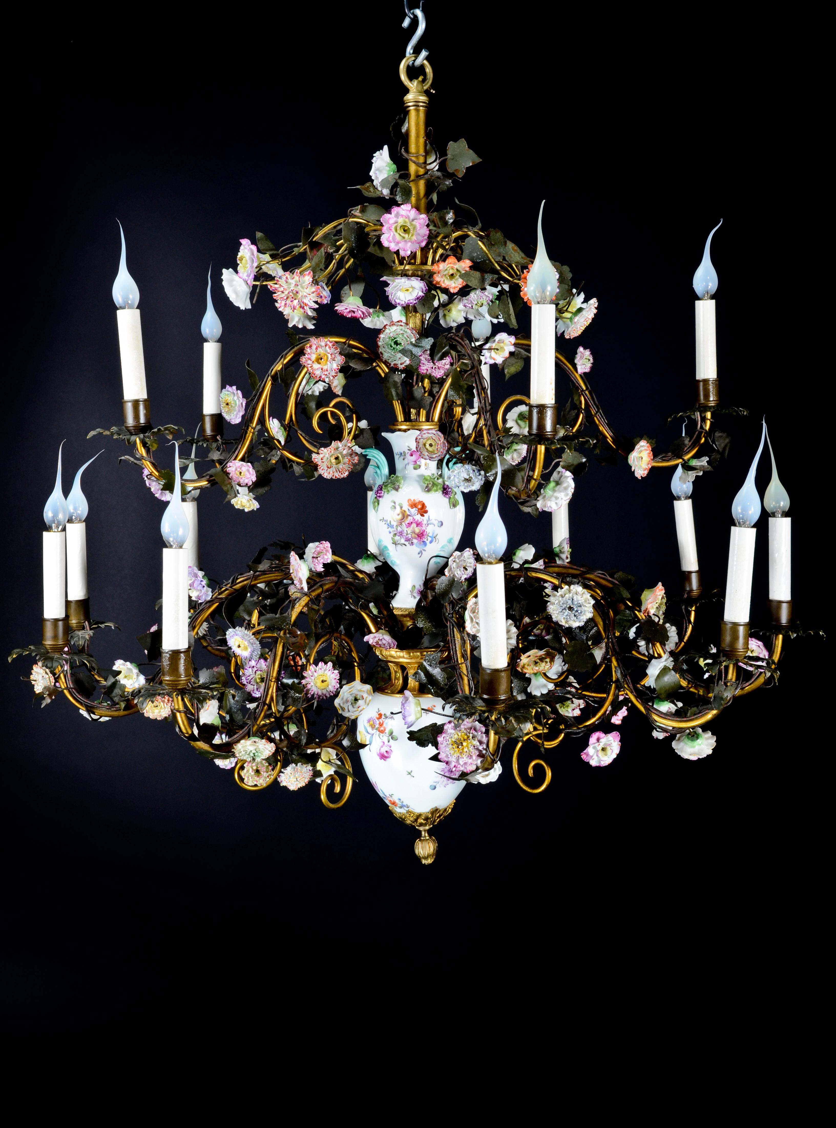 A spectacular and highly important large antique German Louis XVI style Meissen porcelain, gilt bronze and patinated tole multi light double tier chandelier of superb craftsmanship embellished with hand painted polychromed enameled porcelain flowers.