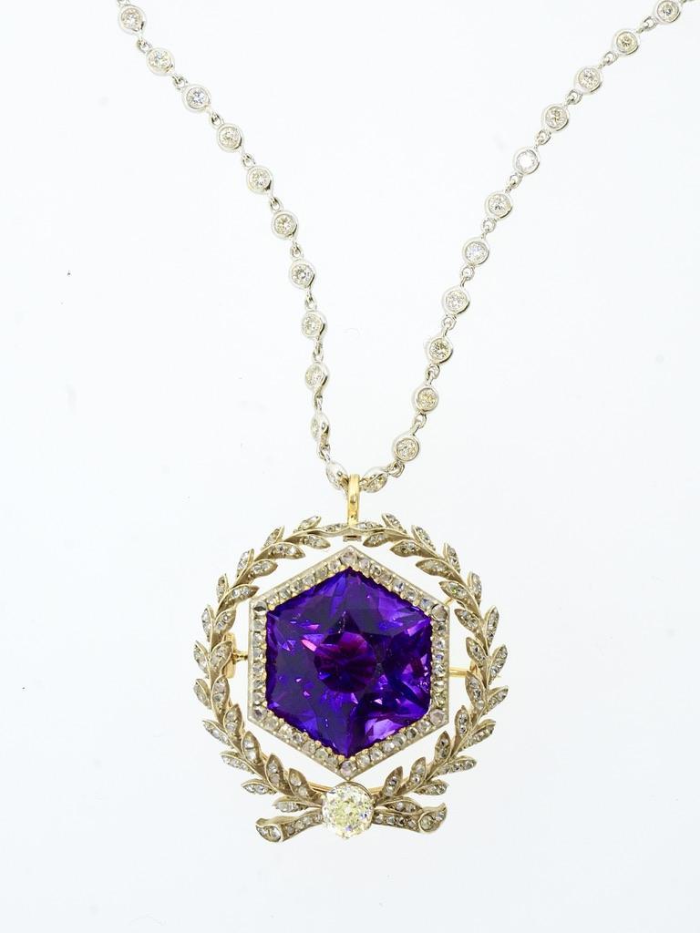 Antique silver topped yellow gold brooch and pendant centering a gem quality natural approximately 22 ct. Siberian amethyst in a fancy octagonal shape. This stone, prong set, has an intense purple color with red flashes. Surrounding this bright