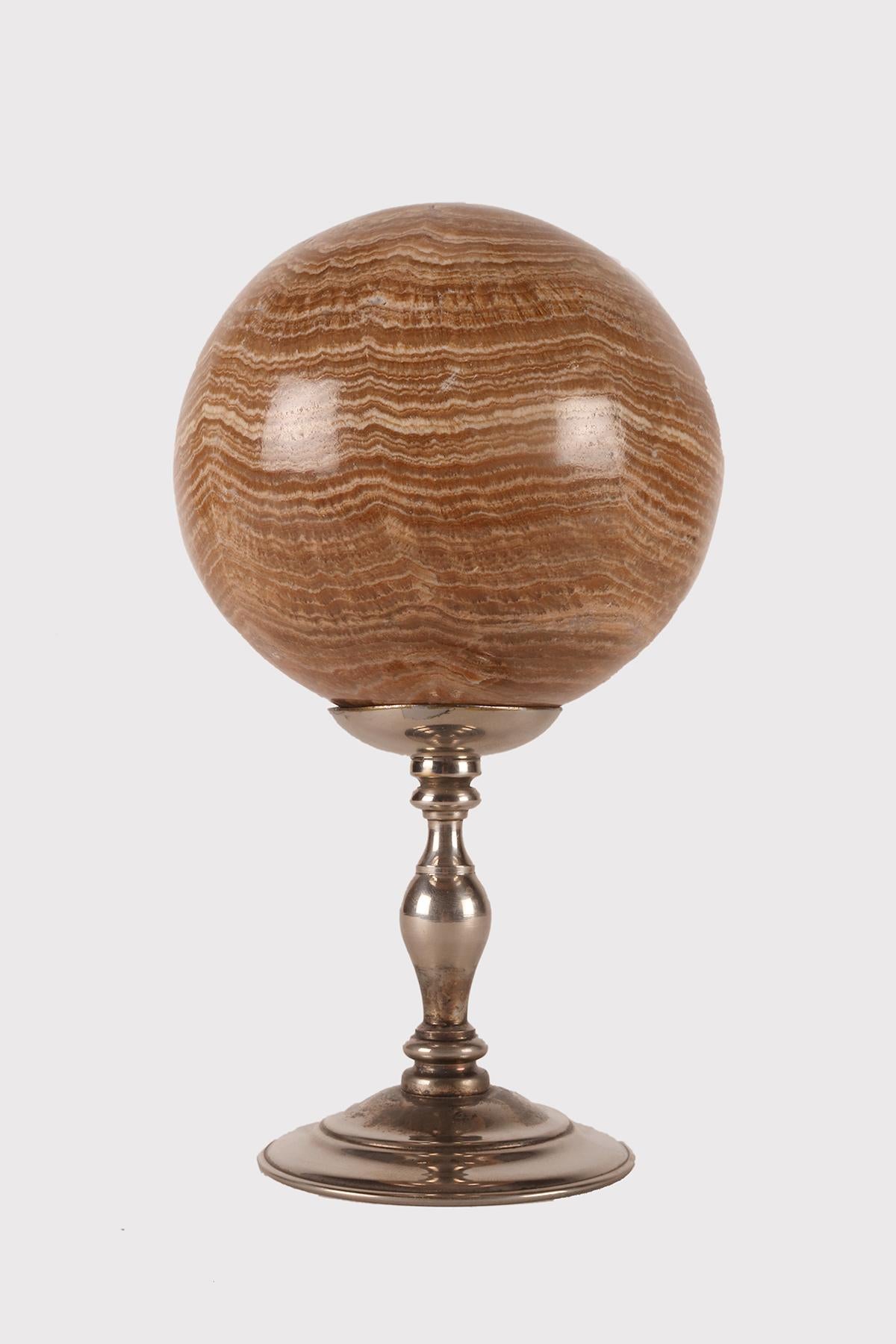 A sphere of Aragonite stone, resting on a base, made of silver which has a cup-shaped stand with a wavy profile that opens upwards with a concave surface. Italy circa 1870.